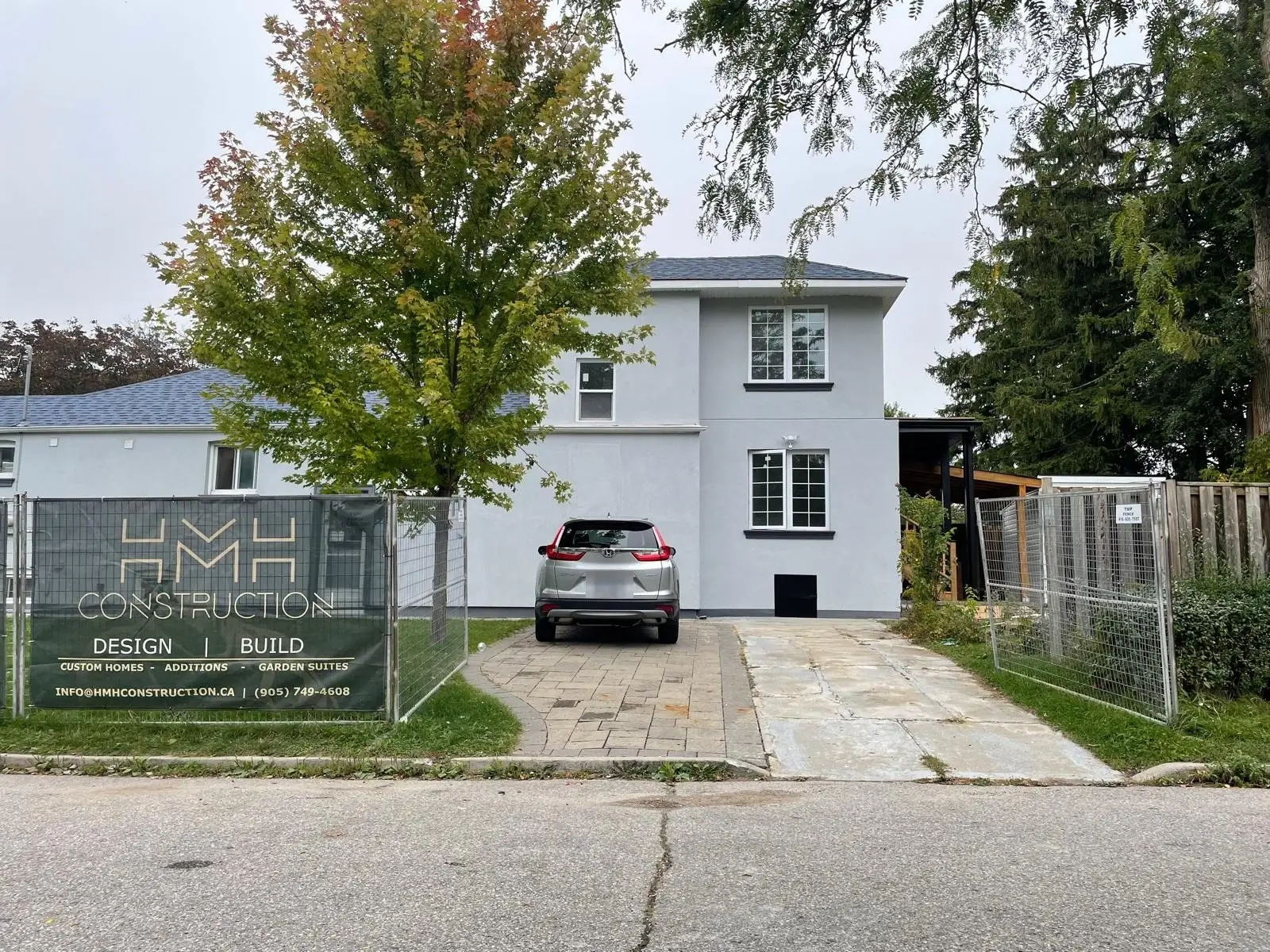 A Scarborough bungalow rebuilt as a two-storey home with stucco and black trim