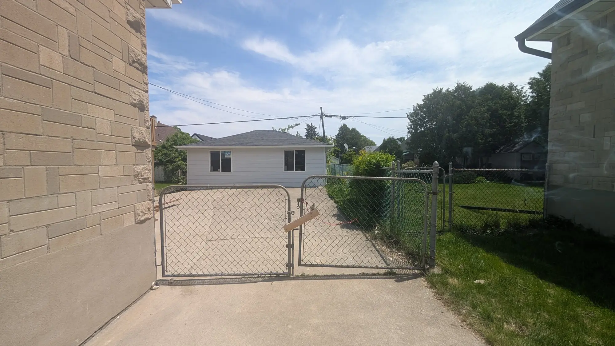 The driveway running the depth of the lot toward the detached garage at the rear