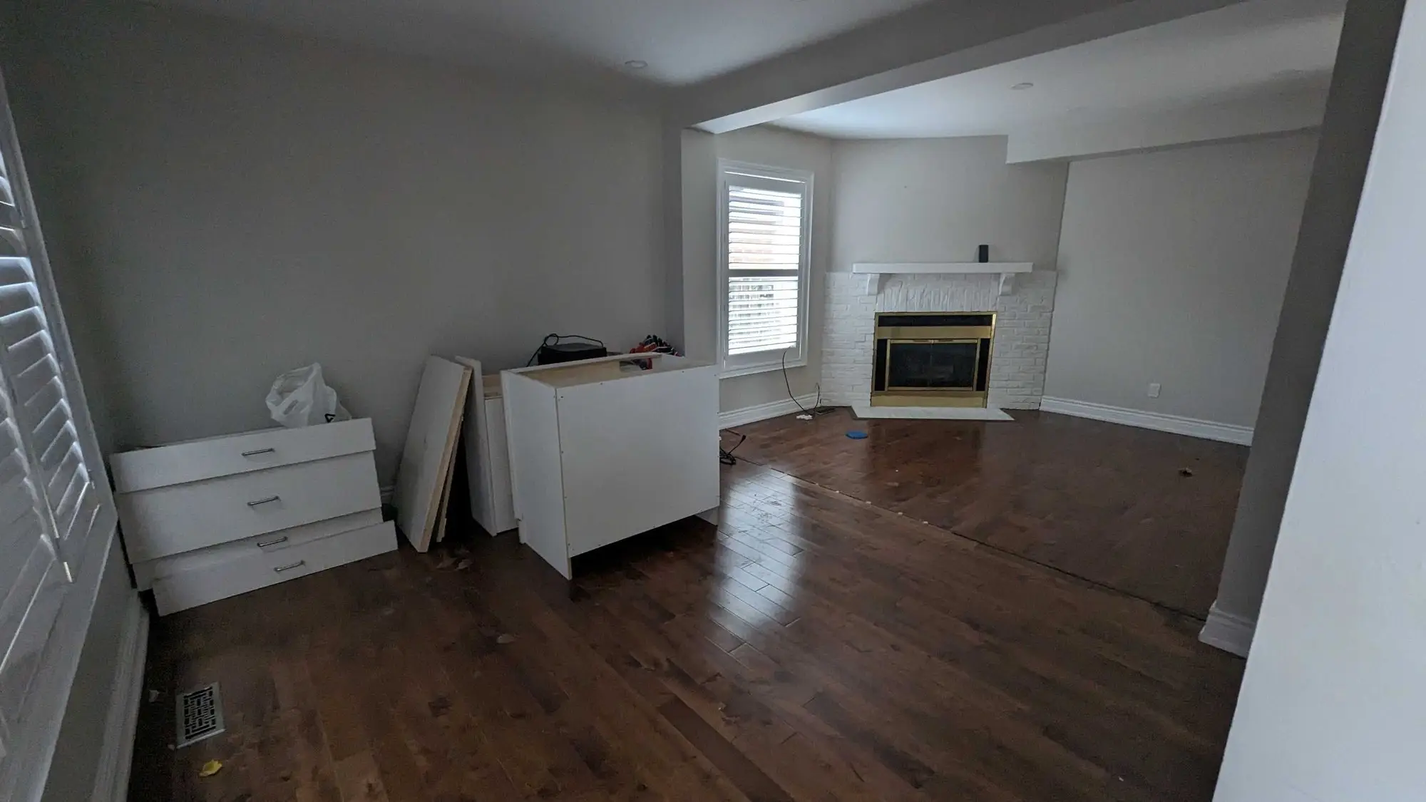 The original living room with hardwood flooring and the existing fireplace