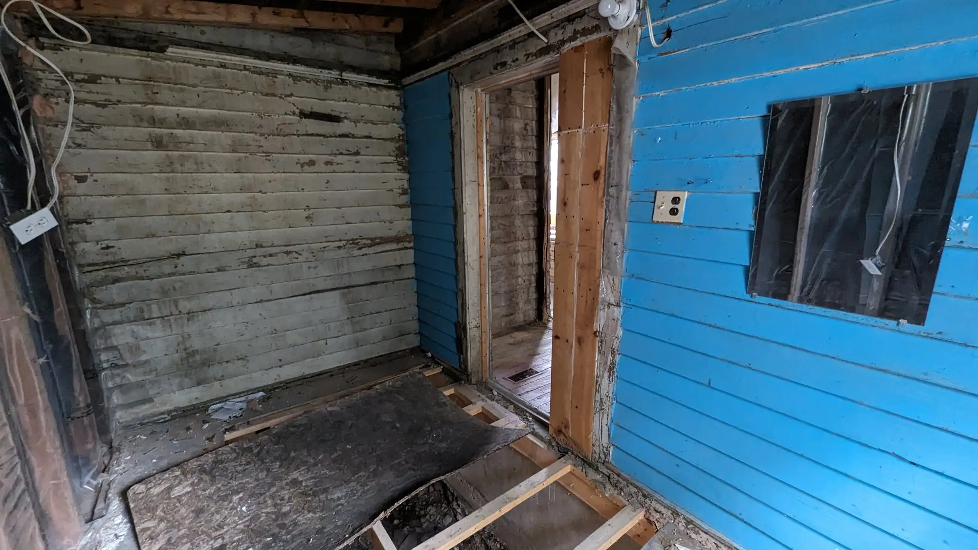 Original painted board walls inside the house before the strip-out