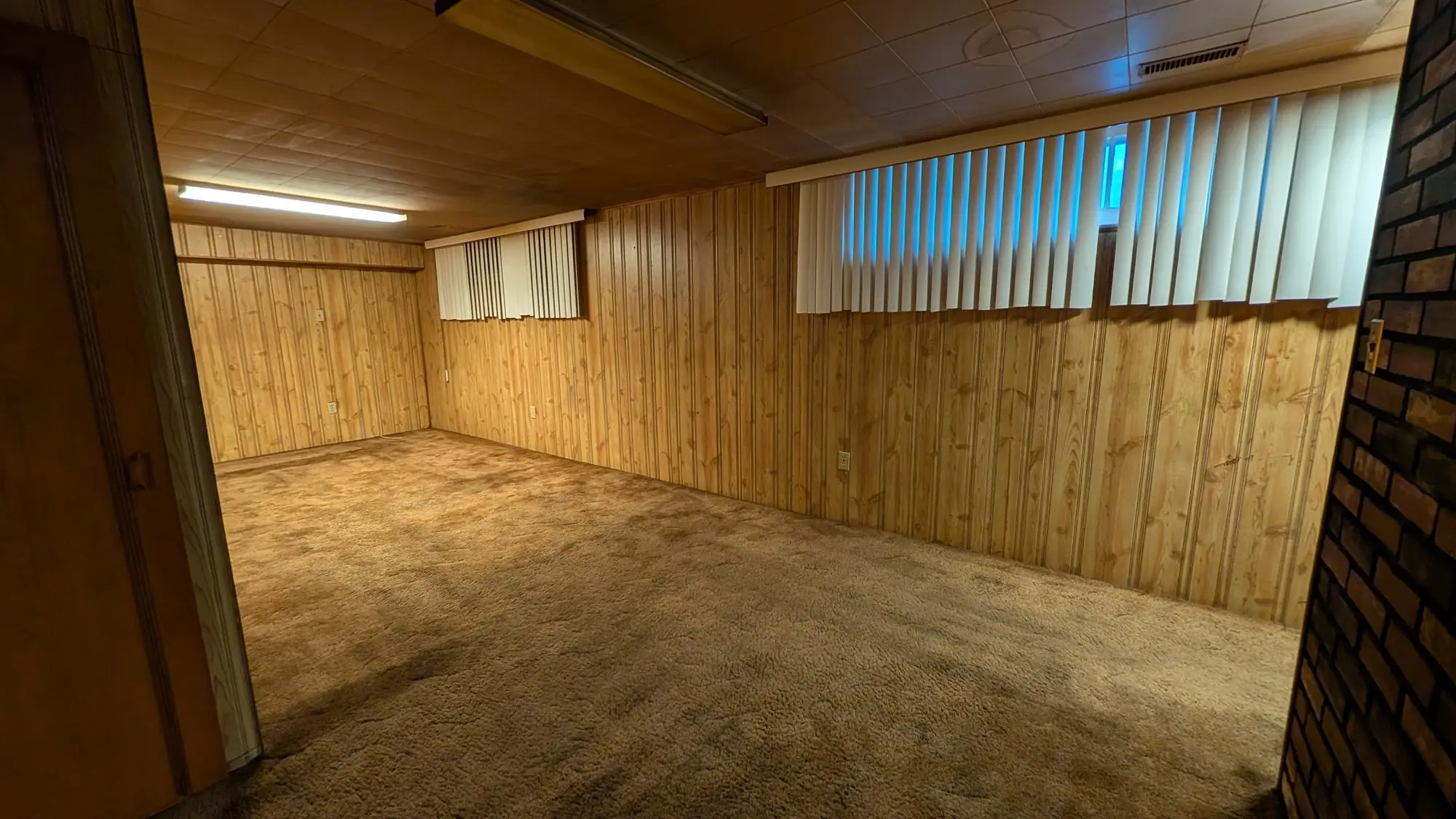 Basement finished in dated wood panelling and carpet