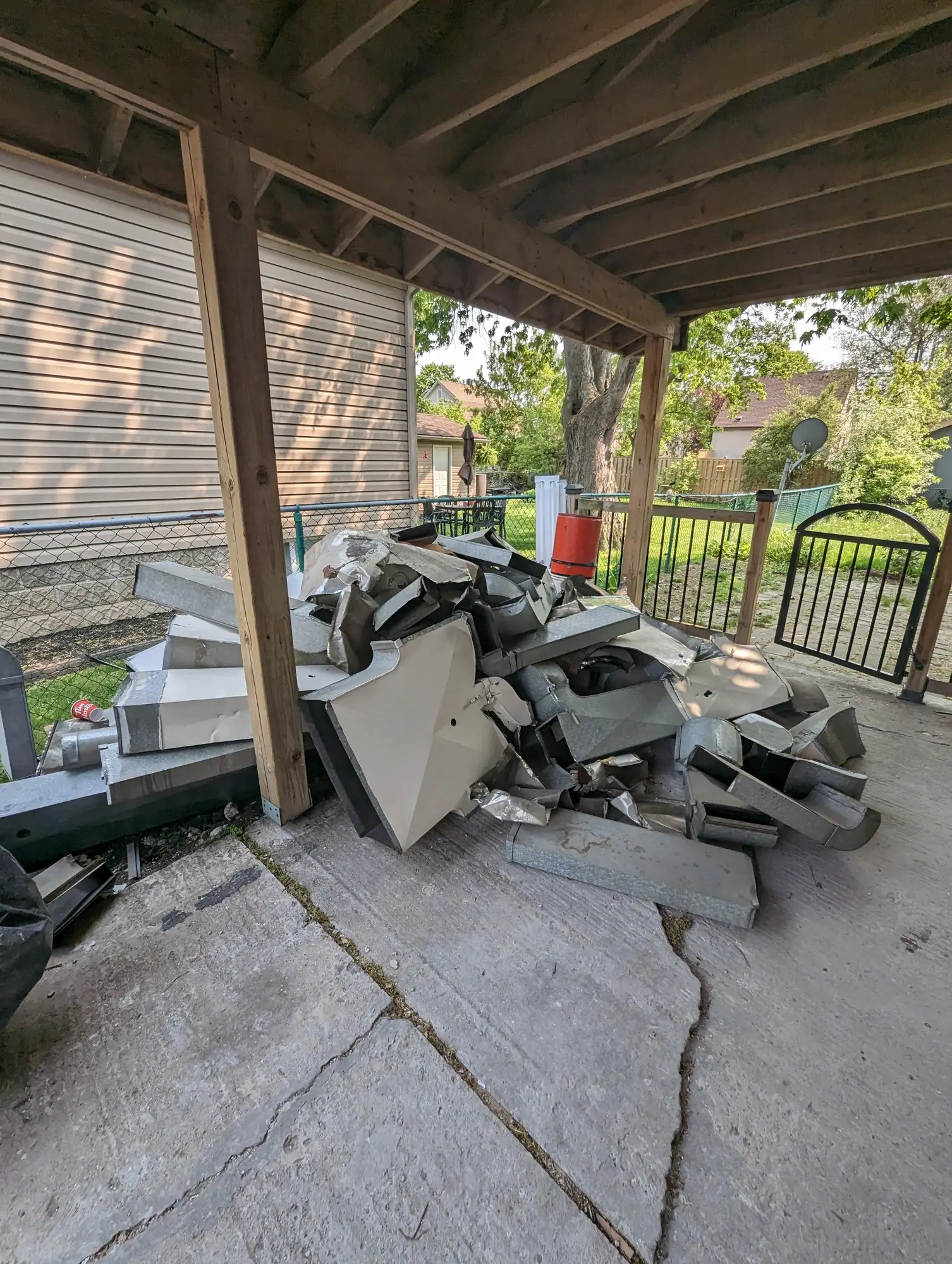 Demolition debris staged under the carport for removal