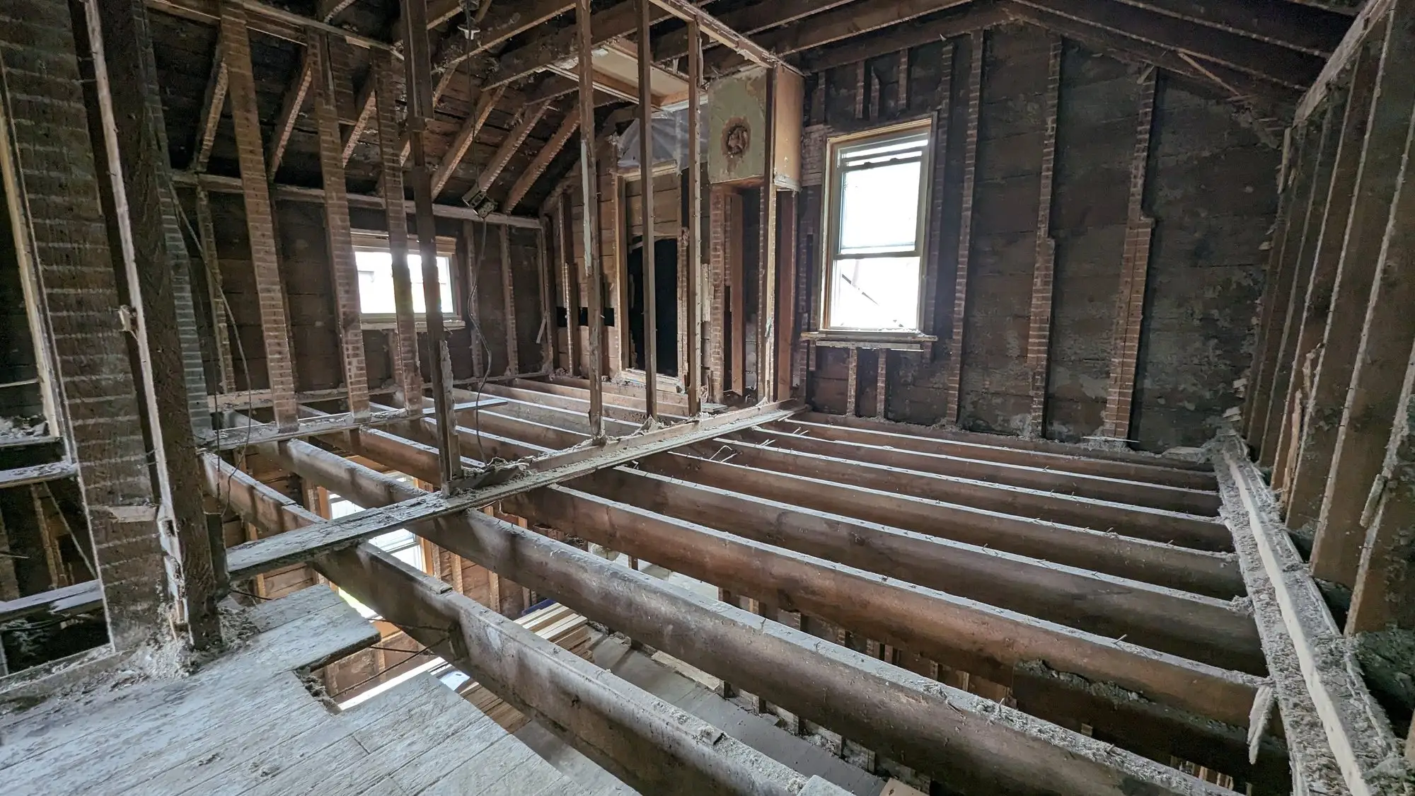 Floor boards removed to expose the original joists across the full footprint
