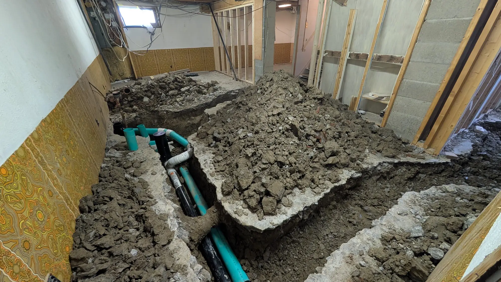 New drain and supply runs laid in the basement trench before backfill