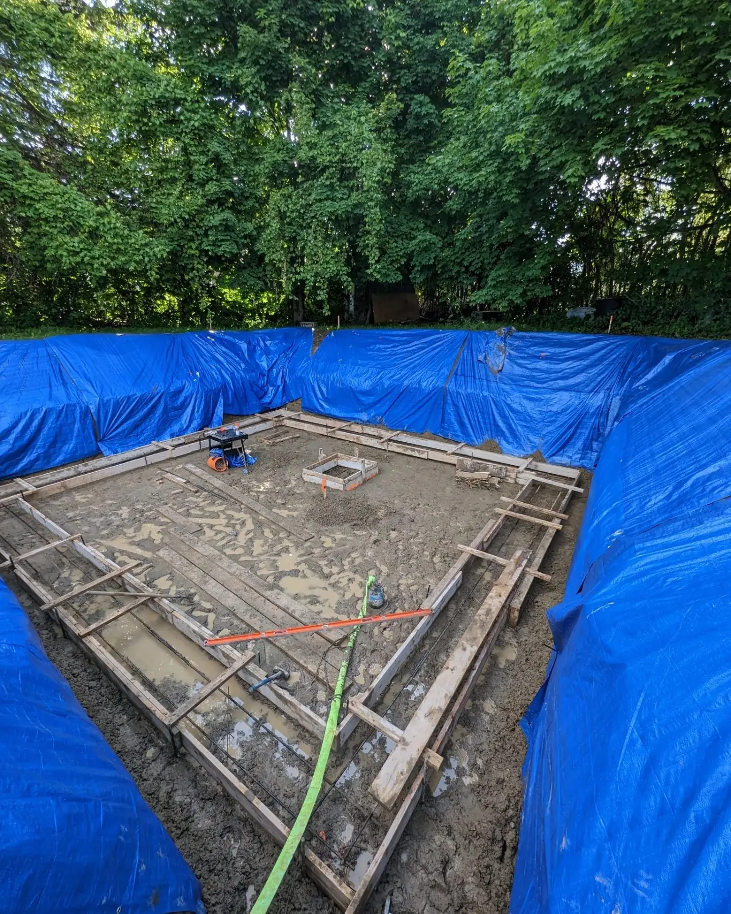 The excavated pad with forms in place across the full basement footprint
