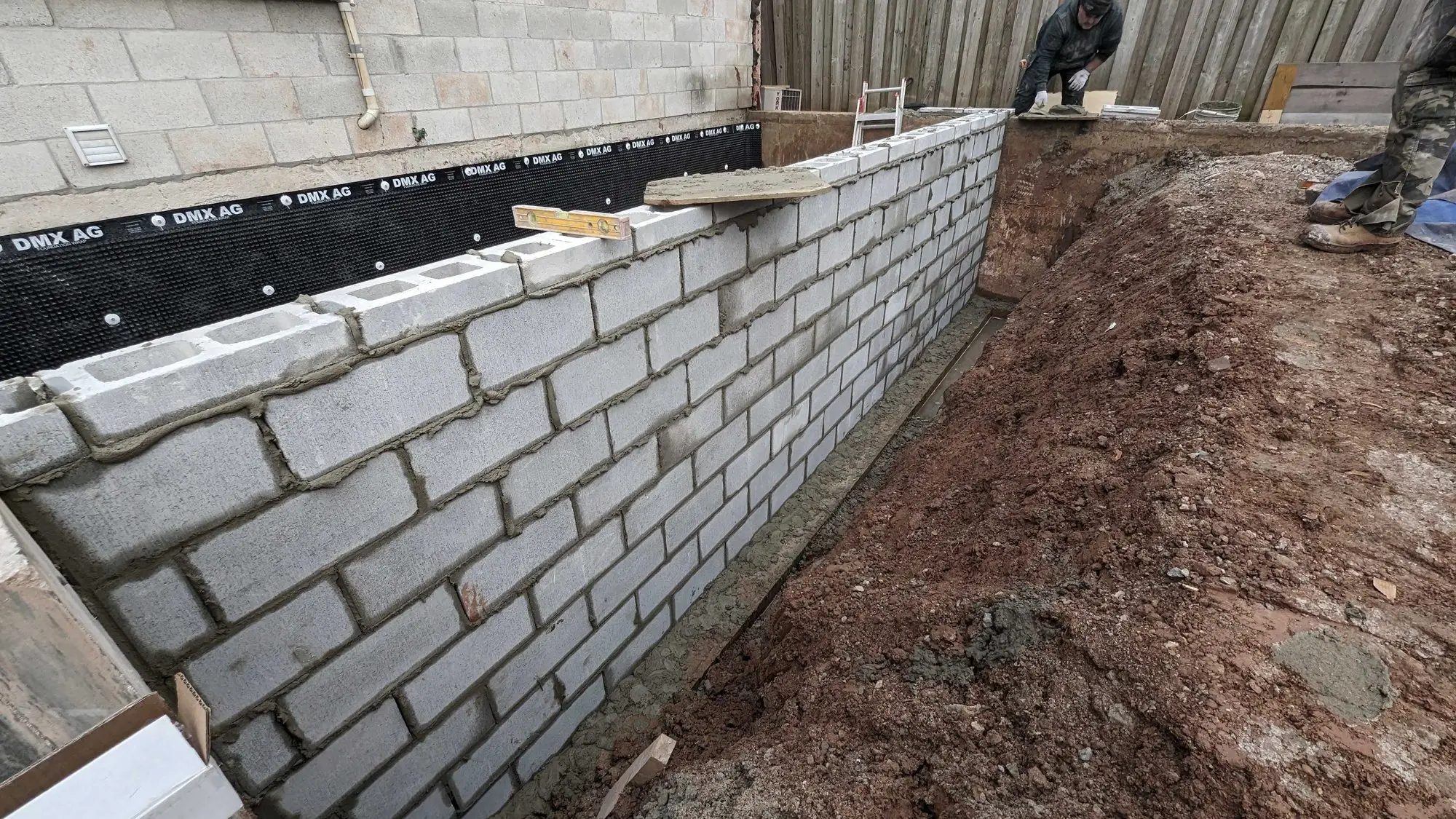 New block foundation wall built off the footings alongside the house