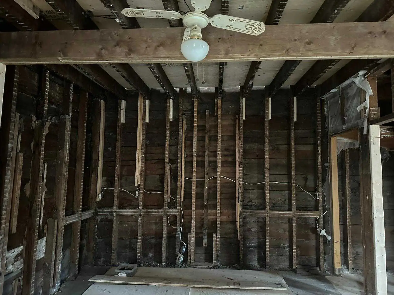 The original timber frame and board sheathing exposed after the interior strip