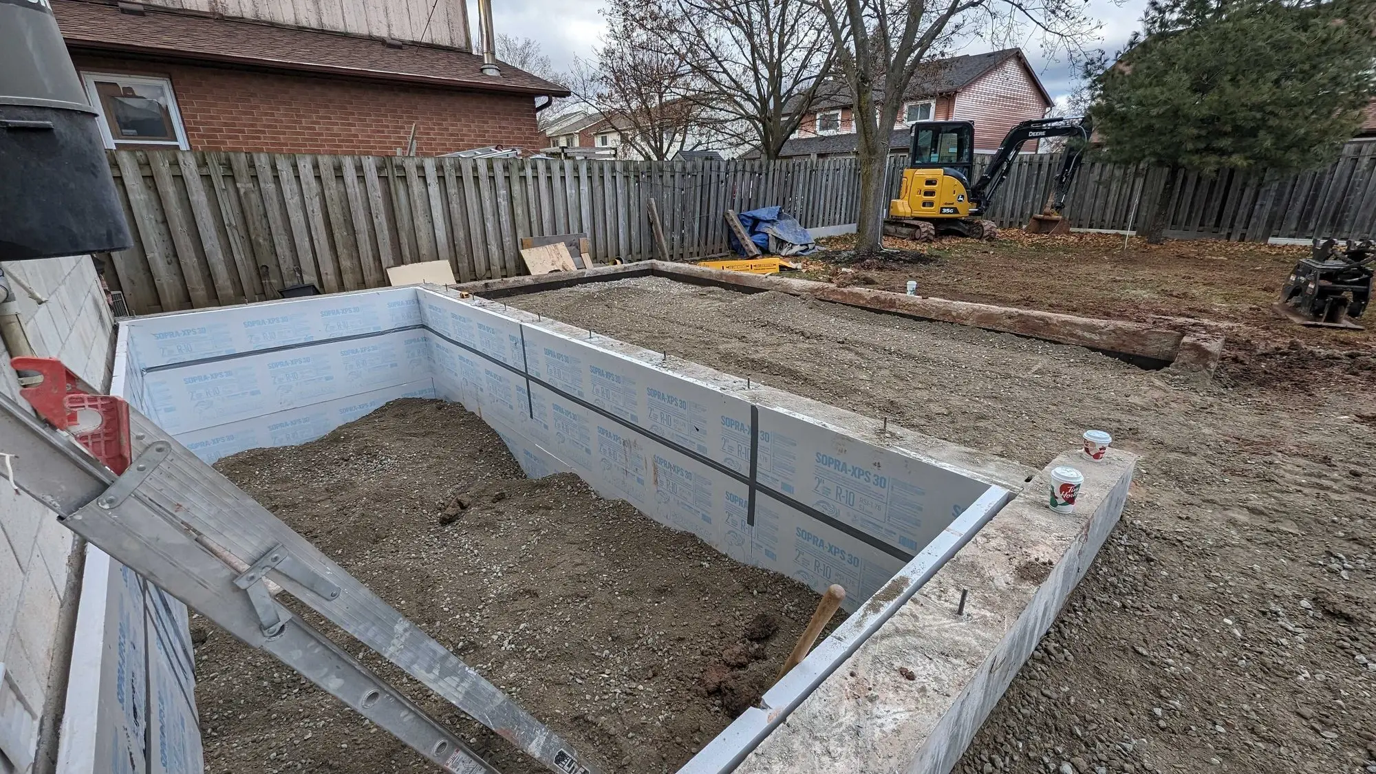 The completed foundation backfilled, with the addition footprint squared out