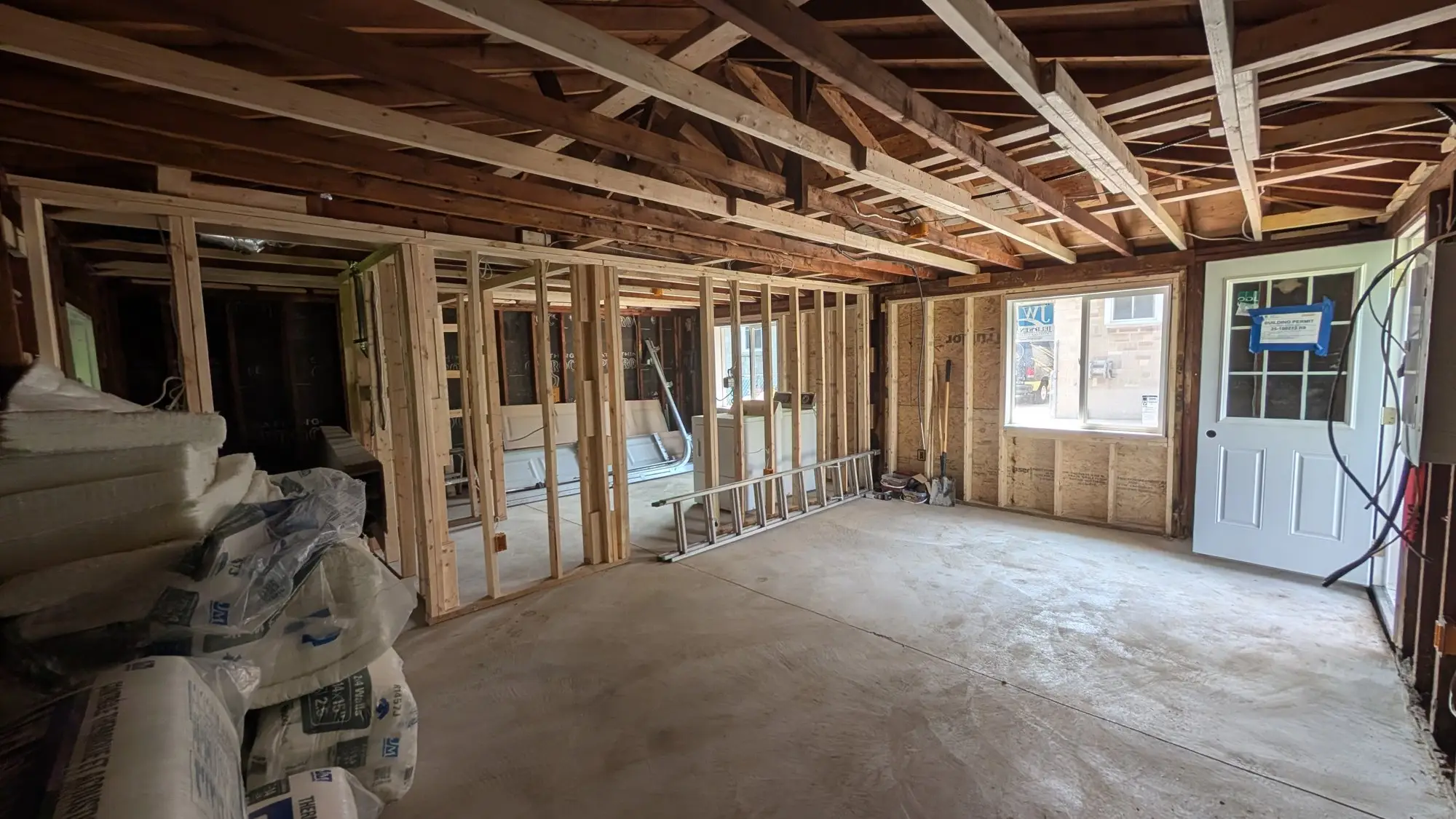 Wide view of the gutted main floor with new partition framing in place