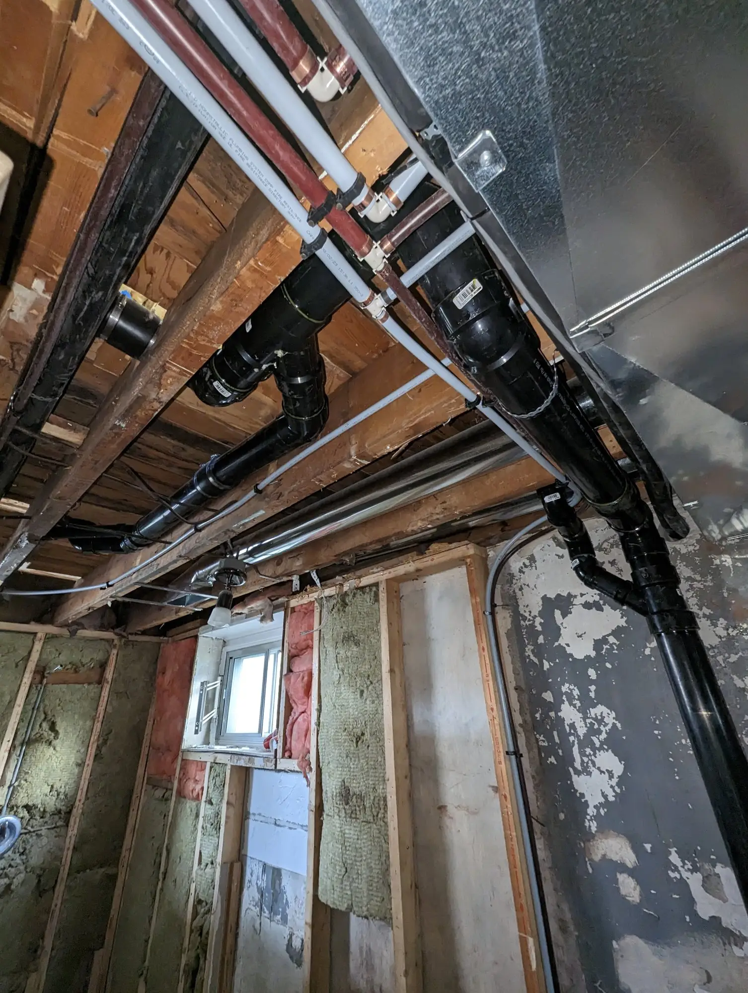 Ductwork rerouted through the basement ceiling to recover headroom