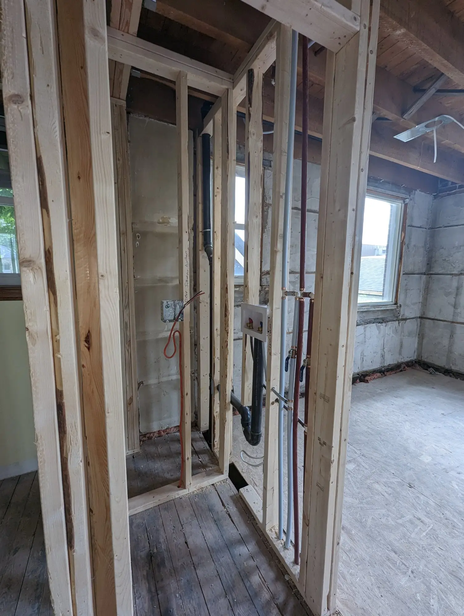 New partition framing with plumbing and electrical rough-in running through it