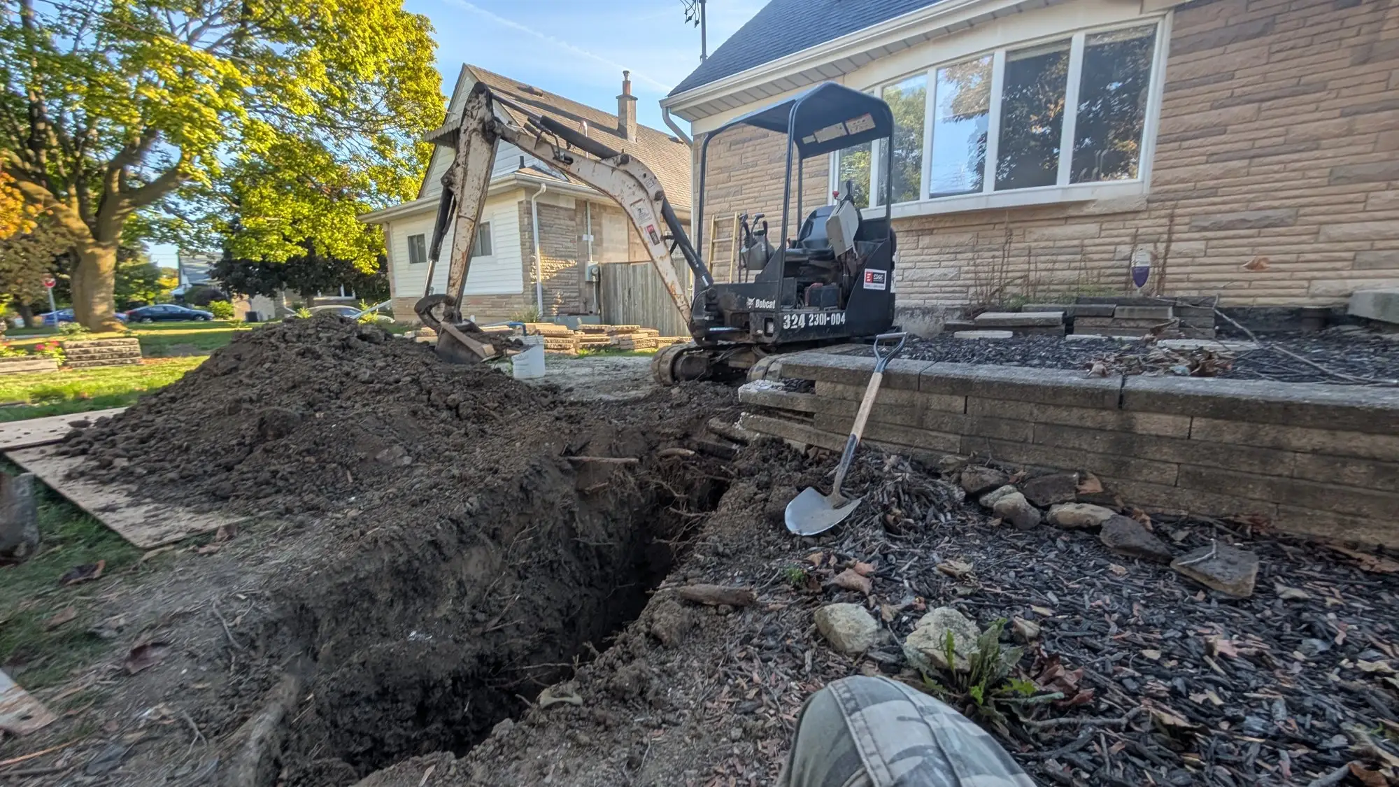 Excavator opening the front yard to upgrade the water service from the municipal main