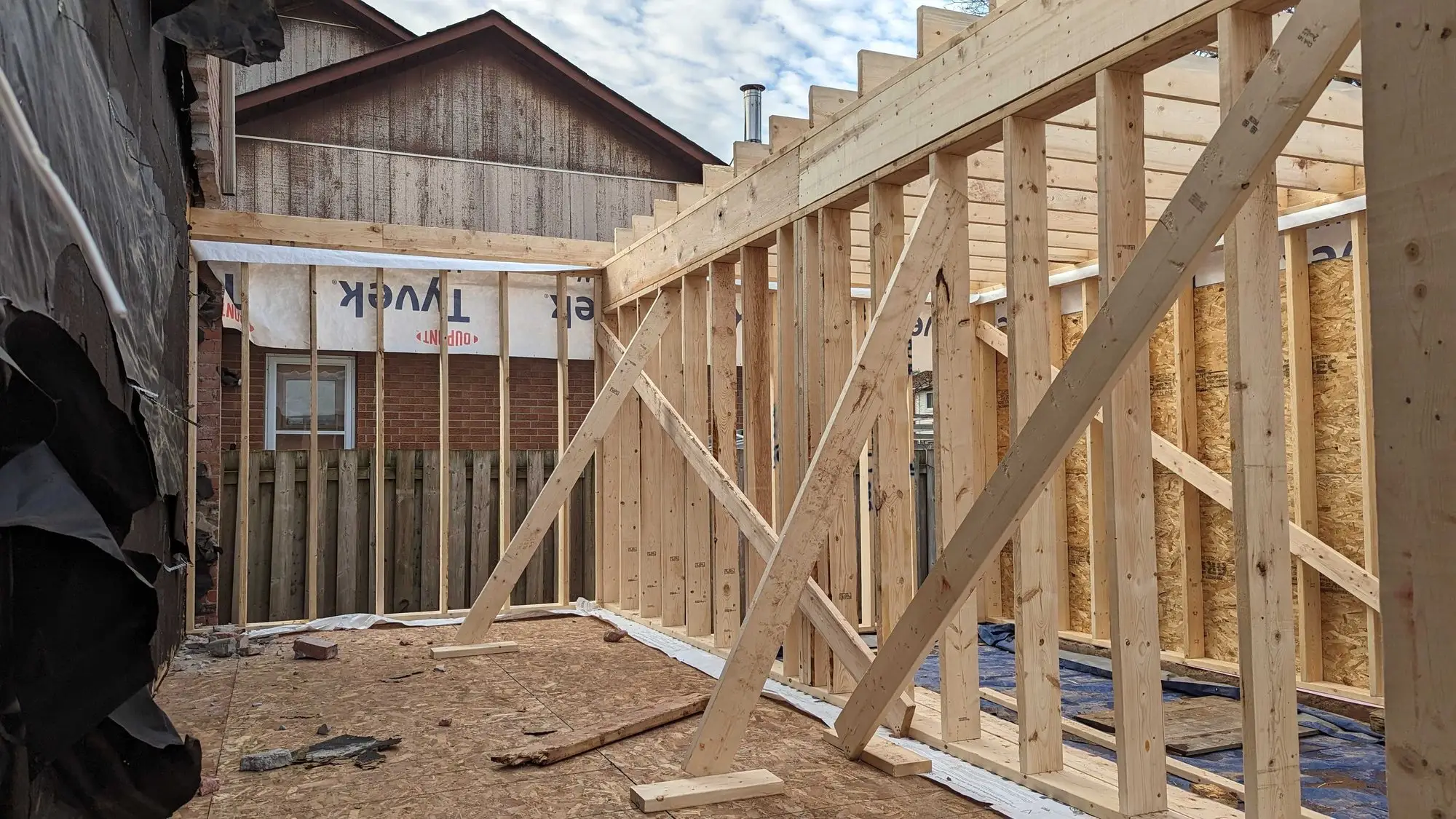 The addition framed and braced, wrapped against the weather