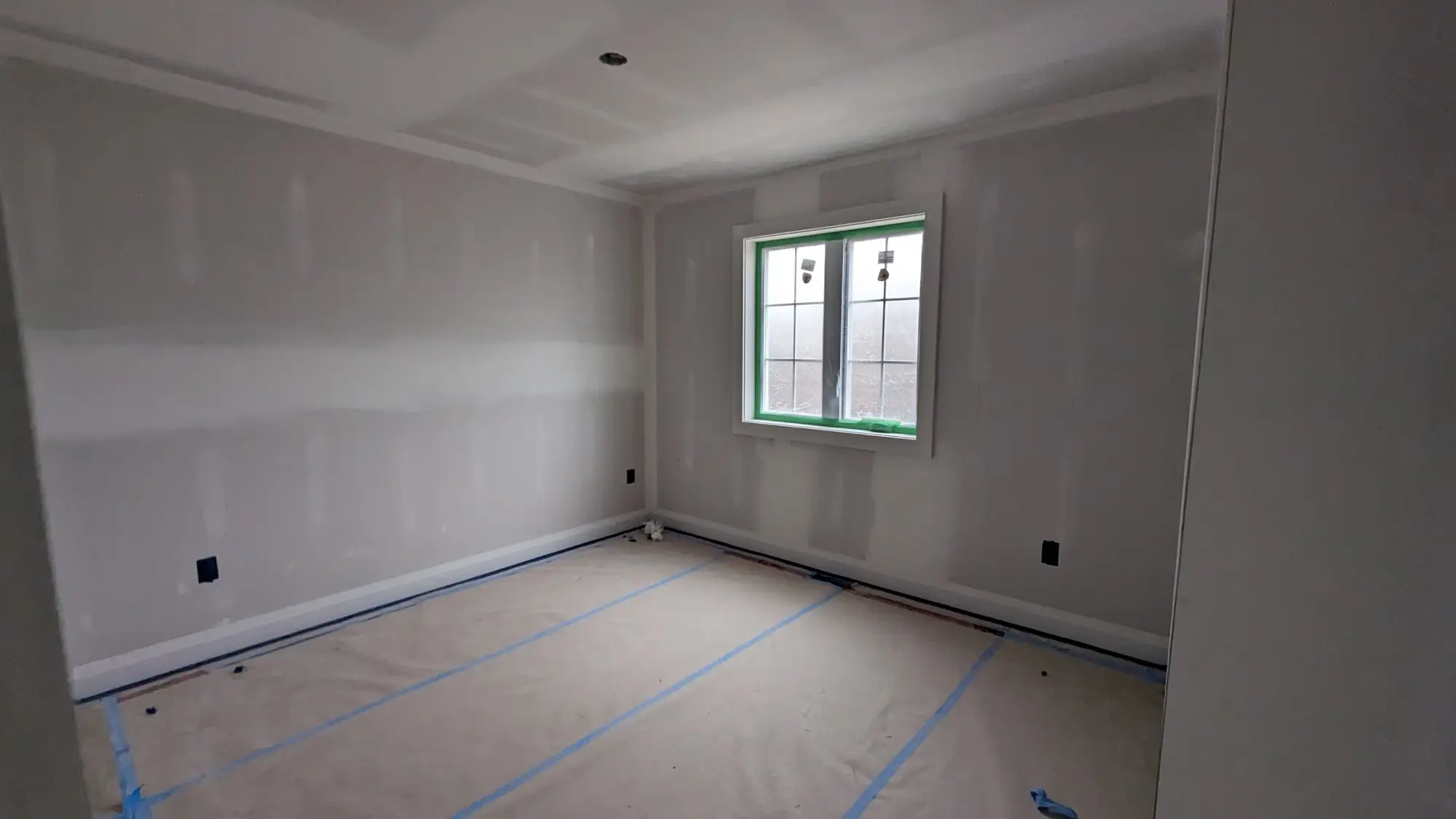 Main floor drywalled and taped with floors protected