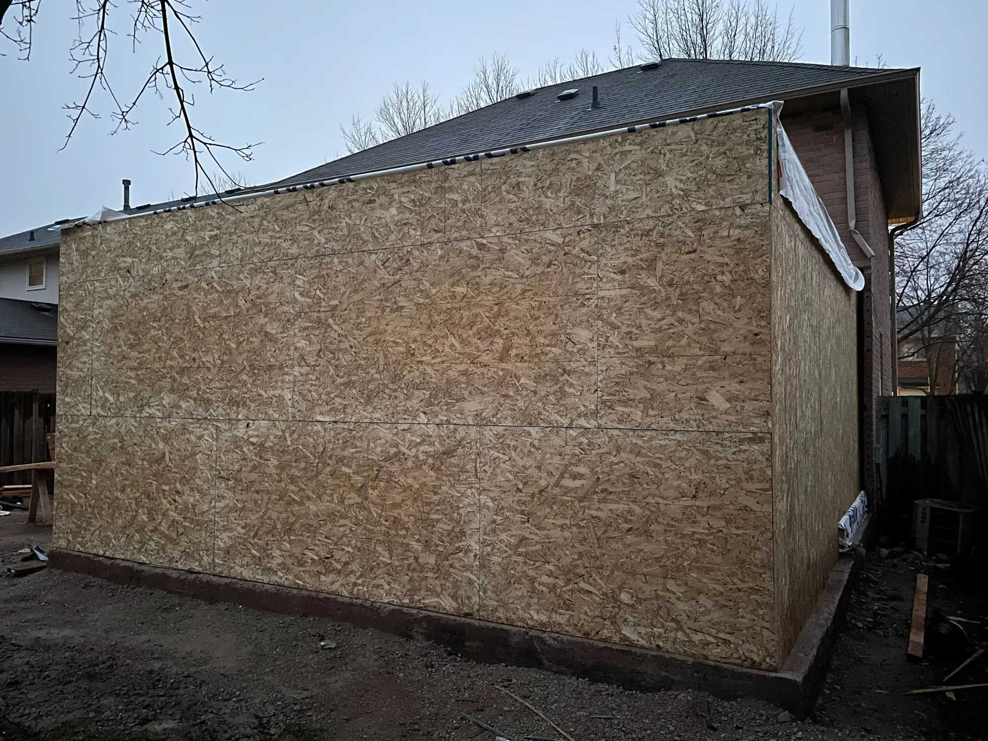The addition sheathed and roofed, closed in against the weather