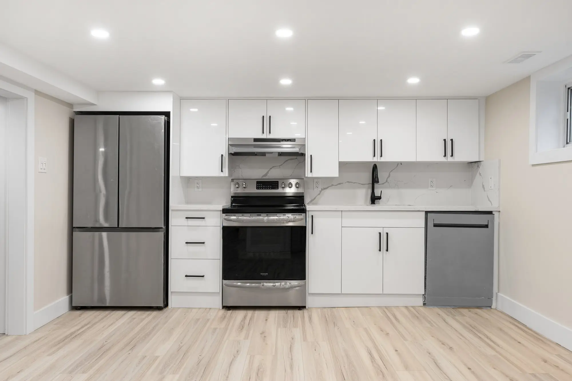 Basement unit kitchen with full-height cabinets and stainless appliances