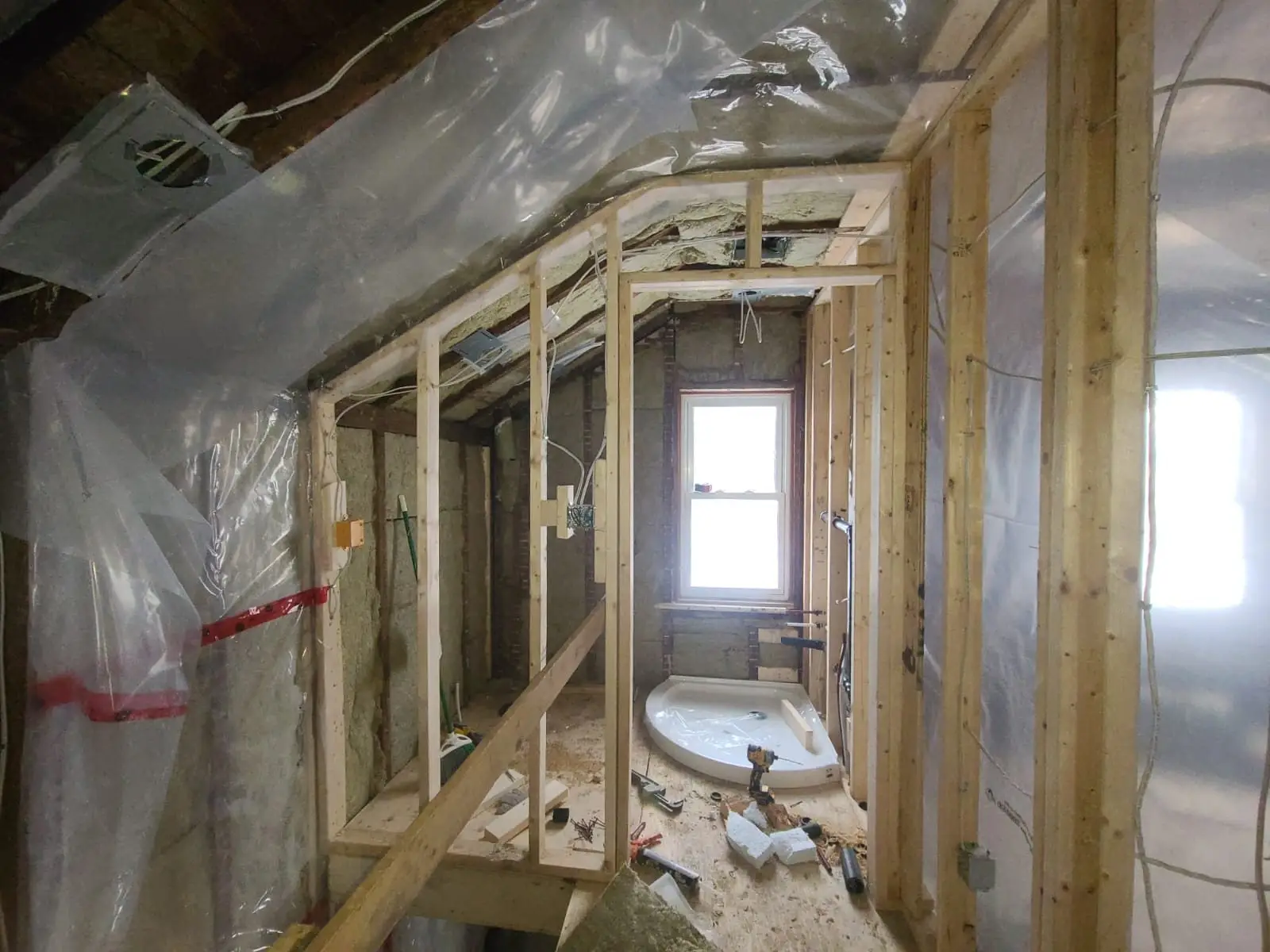 Bathroom framed and roughed in, with the tub set in place