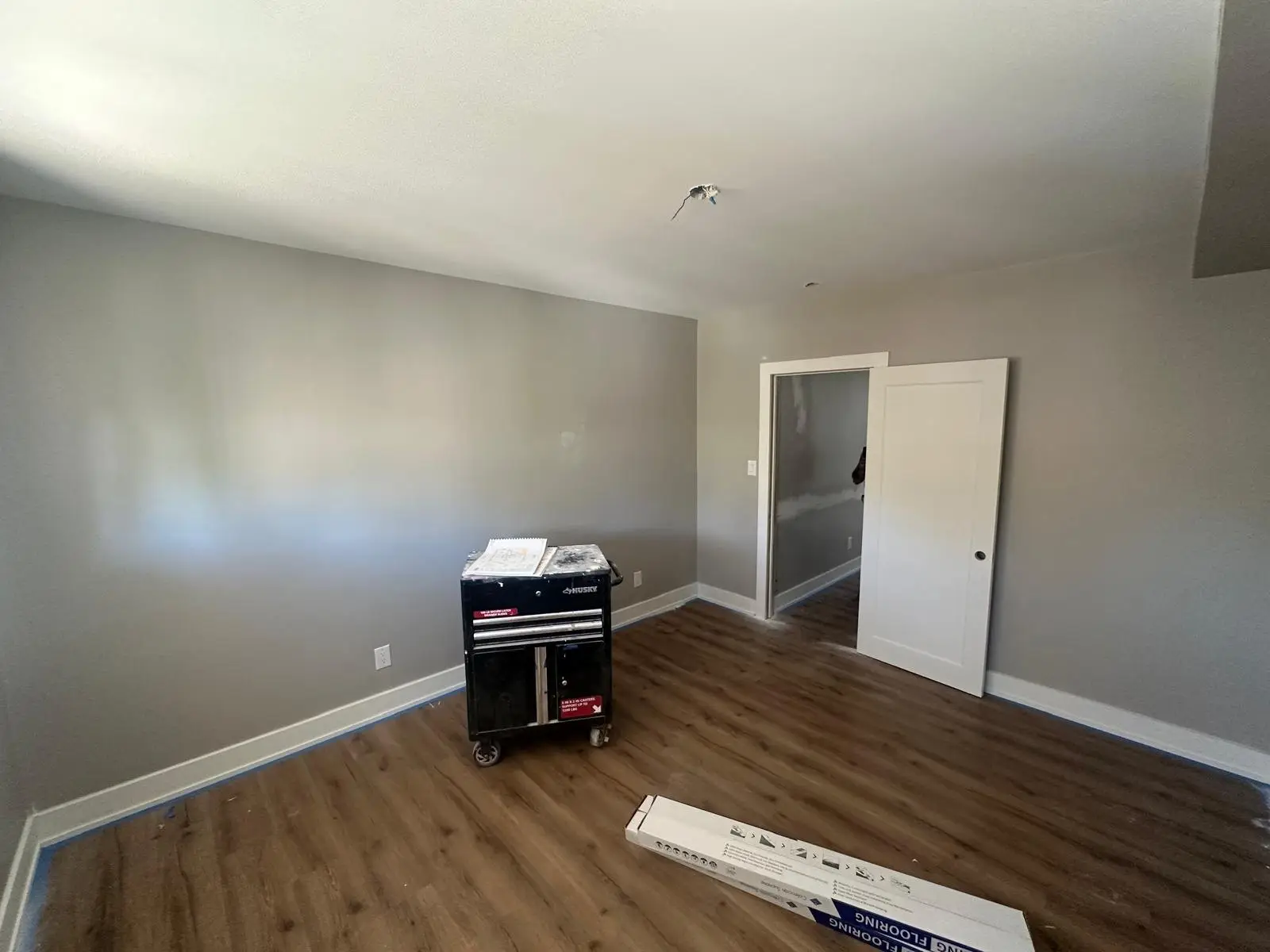 Completed bedroom with new window, baseboard and plank flooring