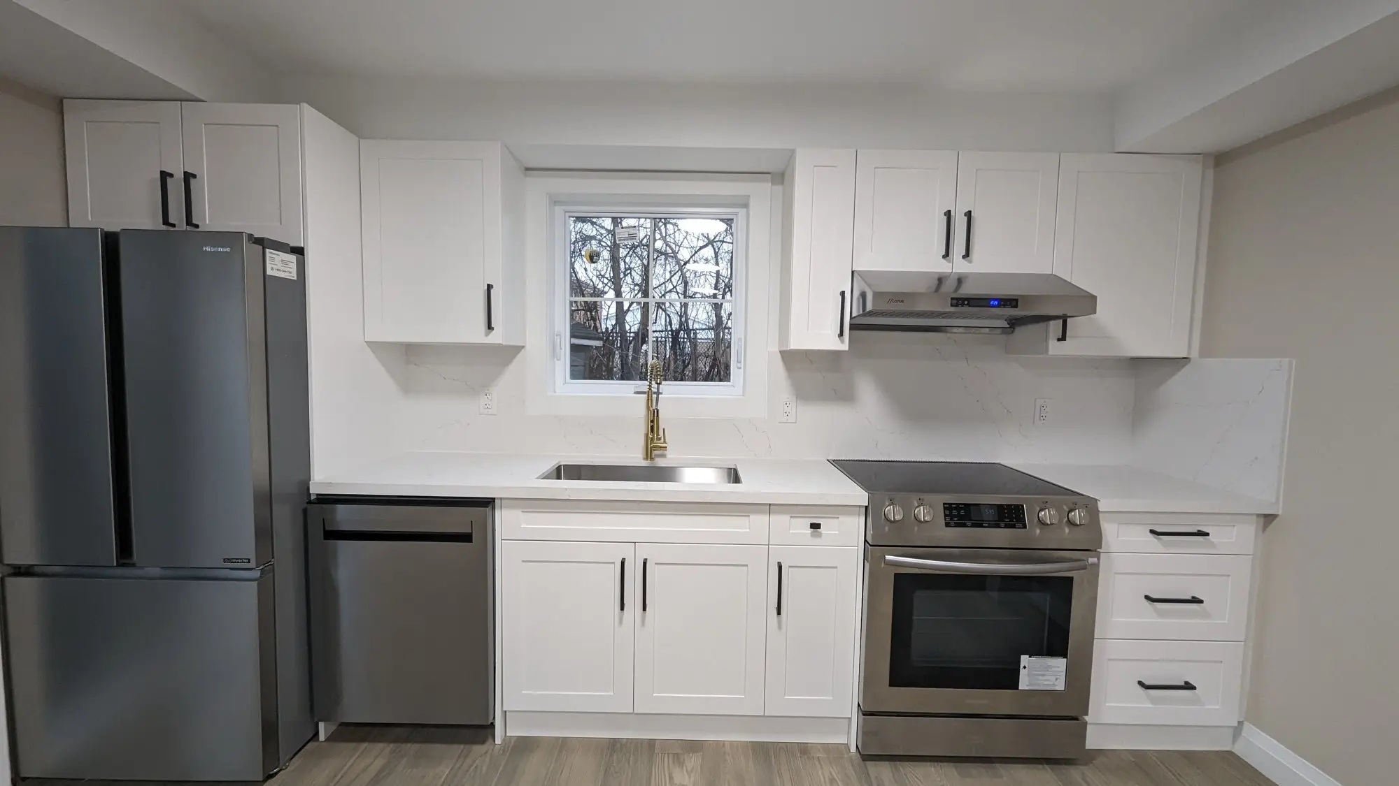 Completed kitchen with quartz counters, stainless appliances and window over the sink