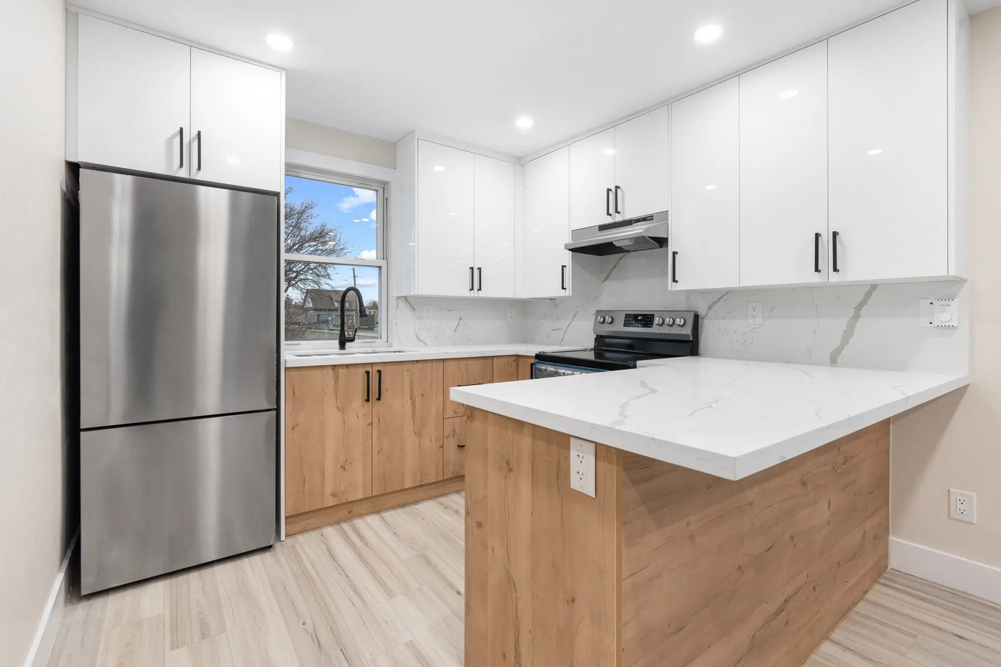 Finished upper-unit kitchen with island, quartz counters and stainless appliances