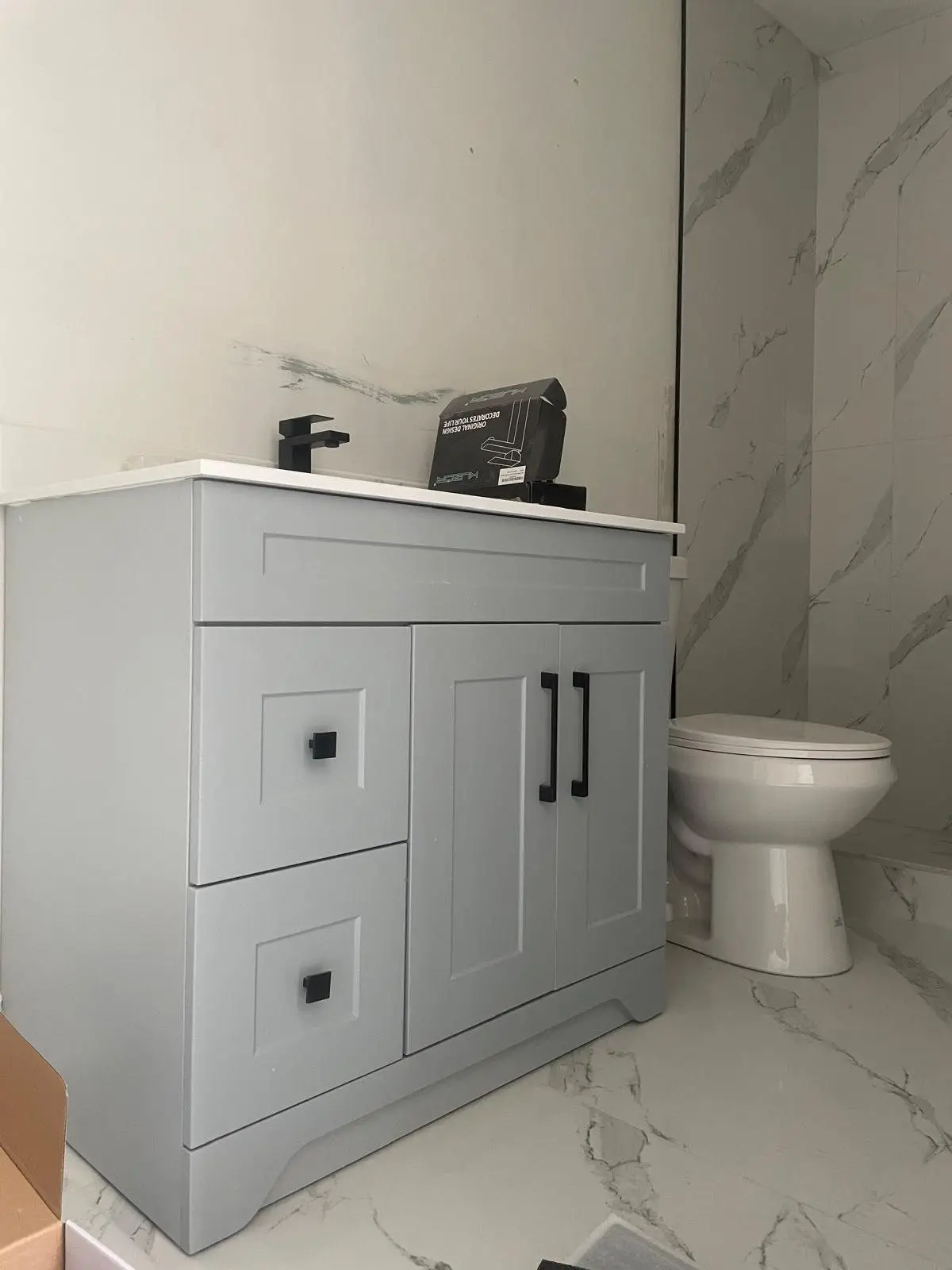 Finished bathroom with shaker vanity and marble-look porcelain