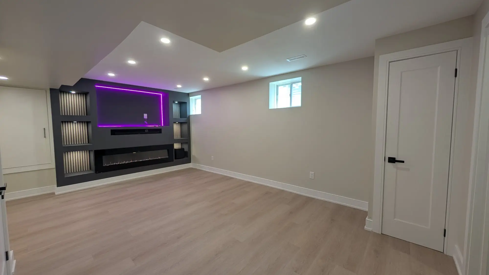 The rec room with the built-in media wall and fireplace