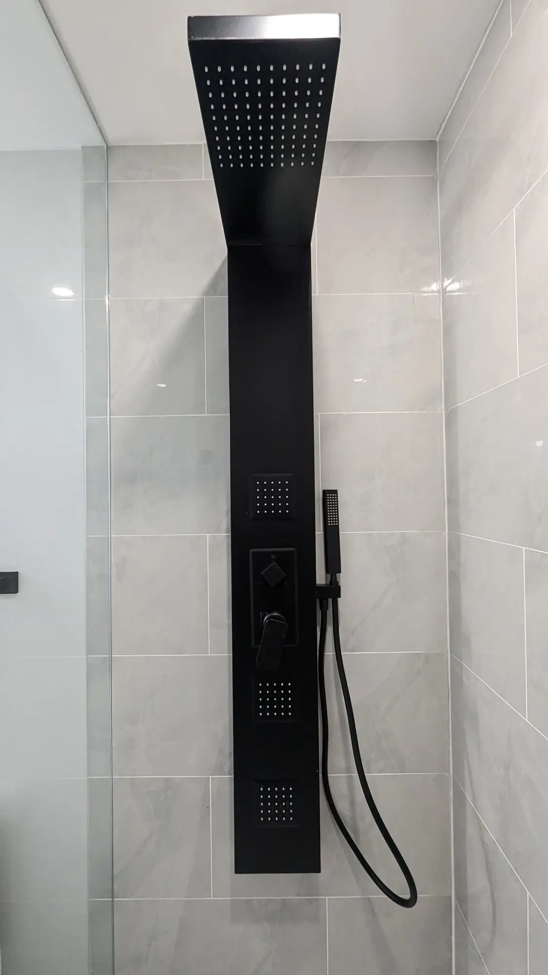 Completed bathroom with rainfall shower panel and full-height tile