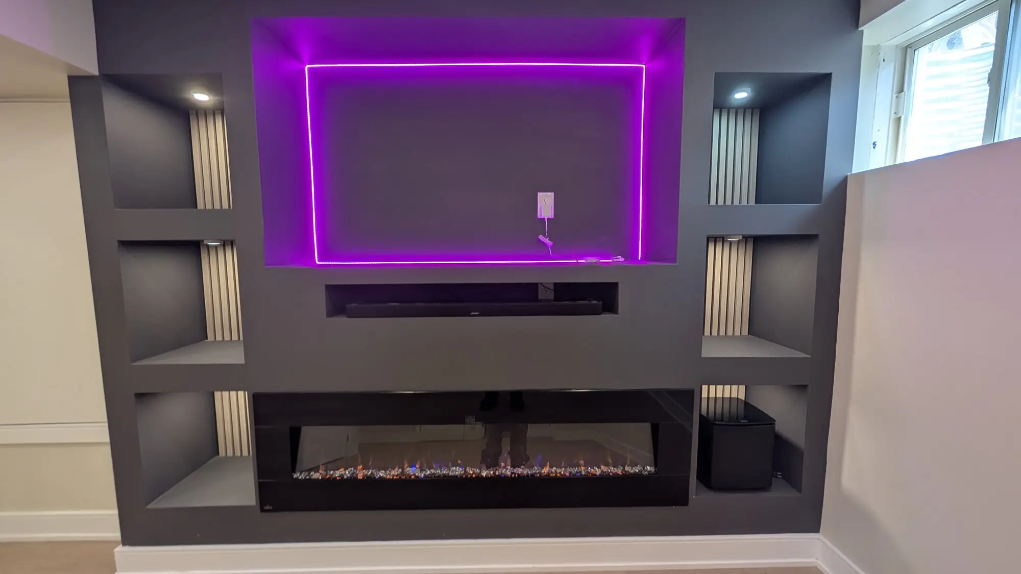 Built-in basement media wall with linear fireplace and integrated LED lighting