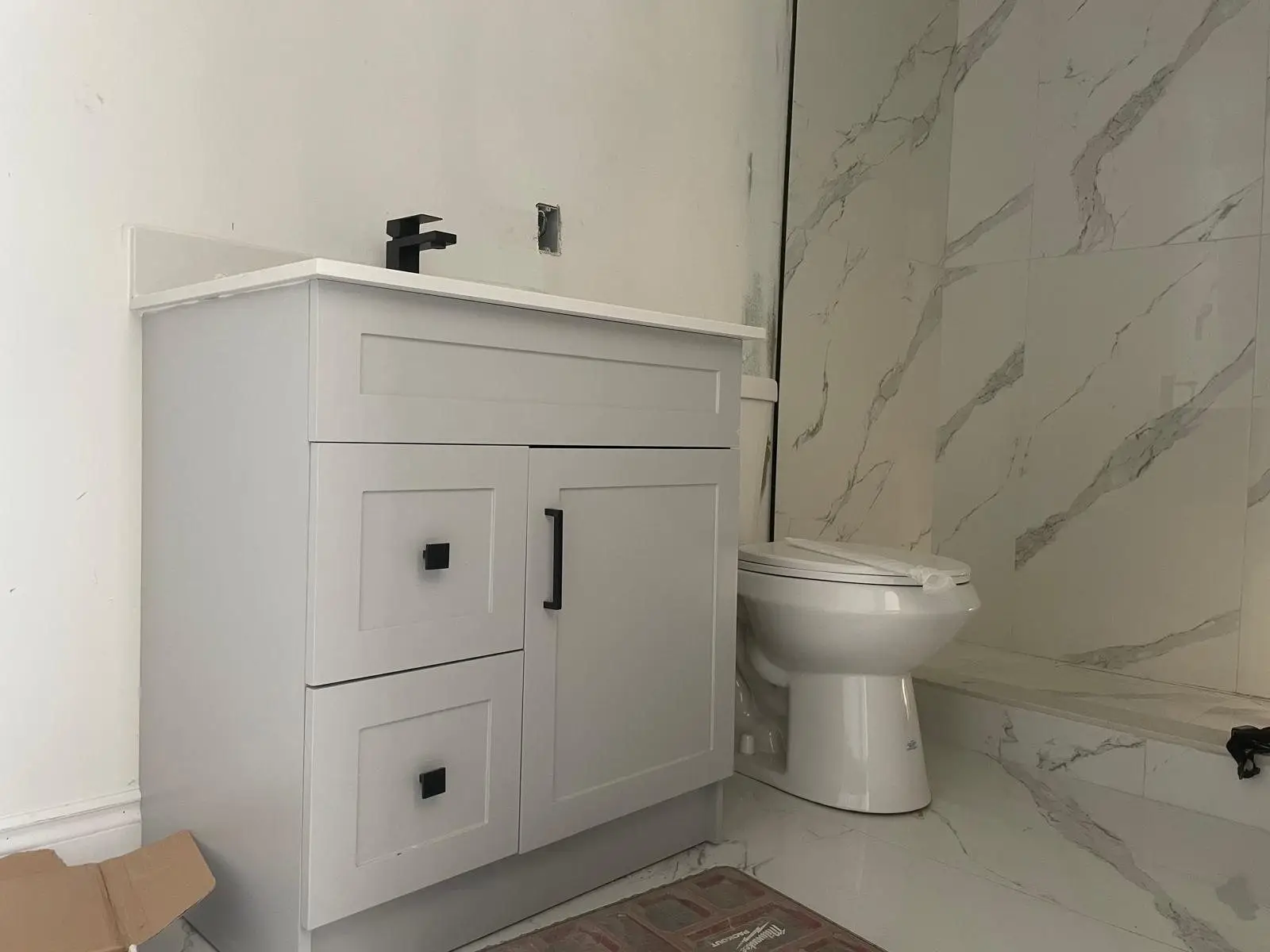 Second finished bathroom with vanity, black fixtures and porcelain walls