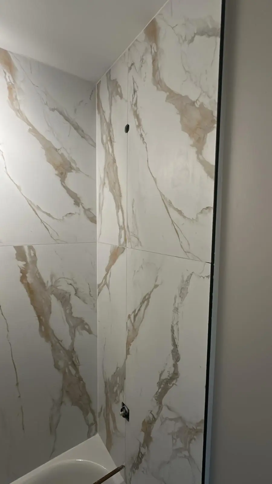 Completed shower with full-height marble-look porcelain tile