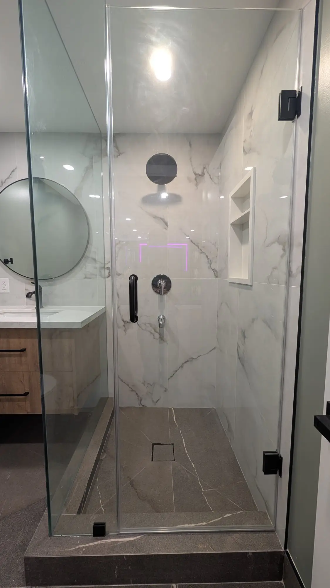 Finished basement bathroom with glass shower and porcelain walls