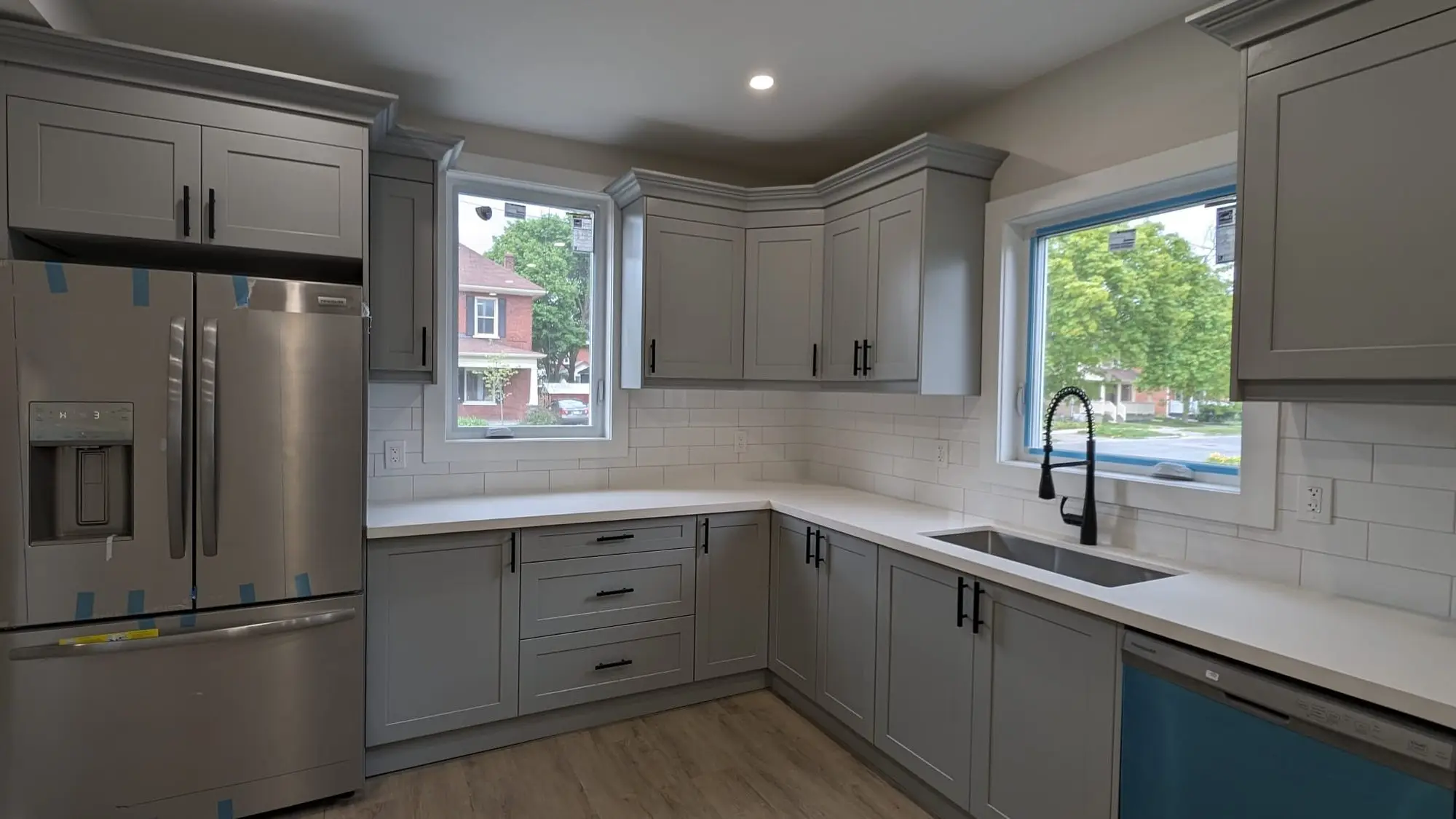 Grey shaker kitchen with quartz counters and white subway backsplash in a century home