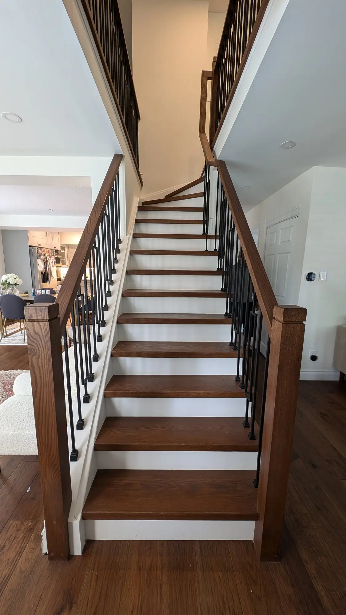 Rebuilt staircase with stained treads, white risers and black metal balusters