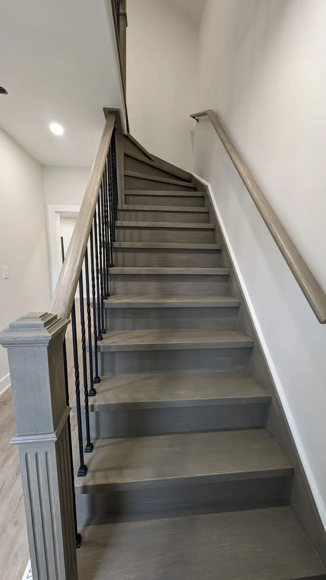 New staircase with stained treads and black metal balusters