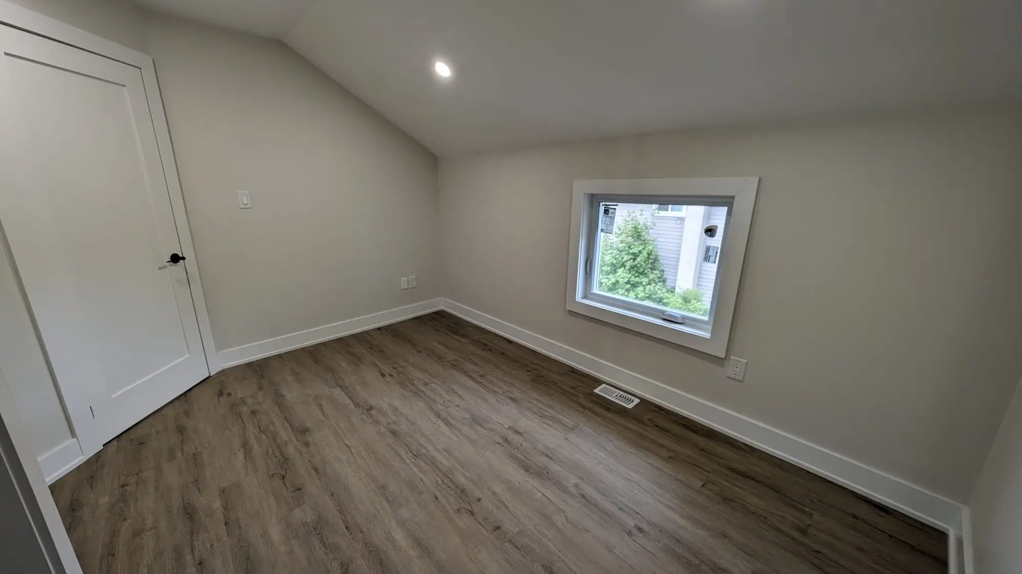 Finished bedroom with plank flooring and new trim