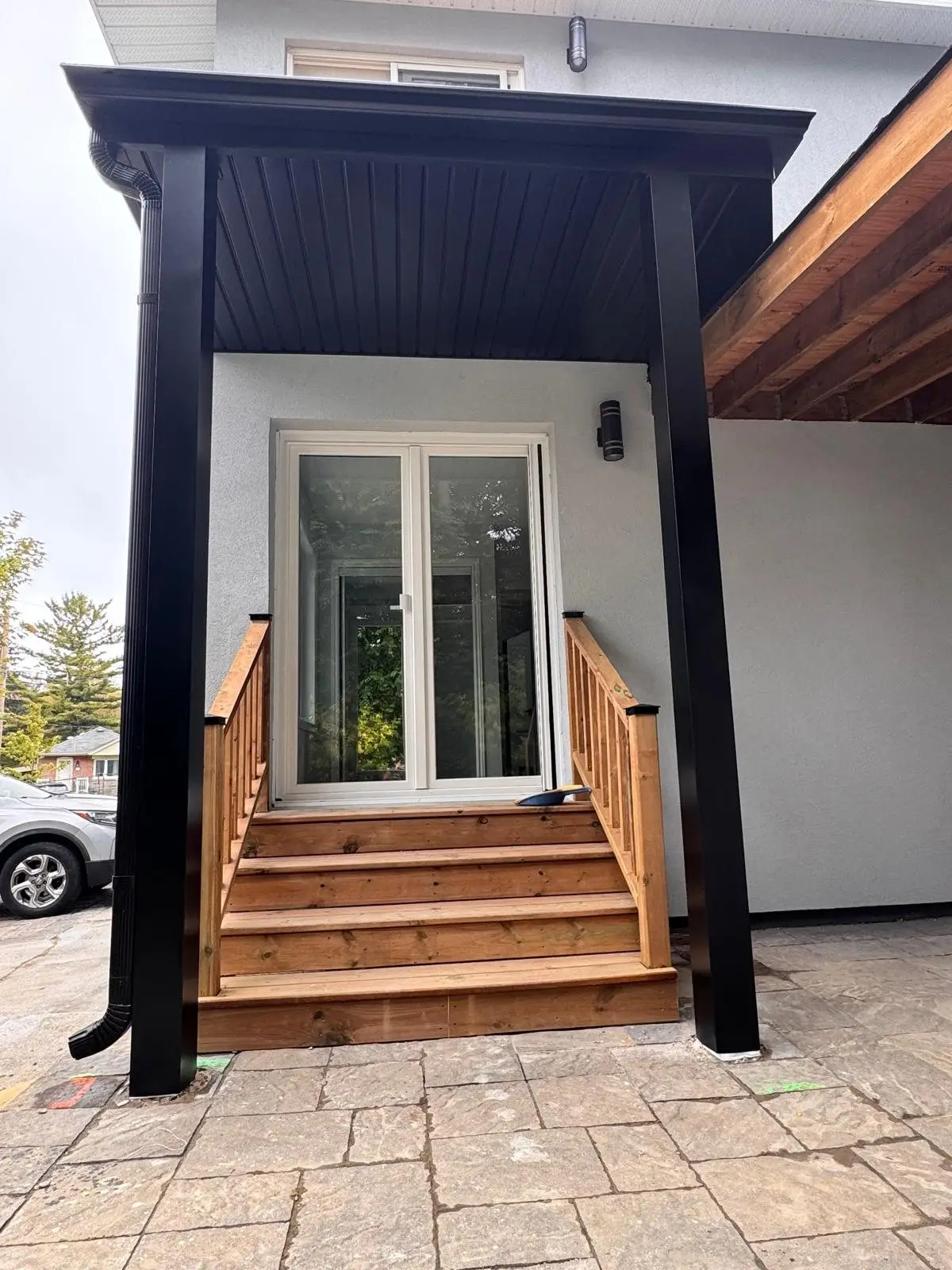 Finished covered entry with black posts, canopy and cedar steps