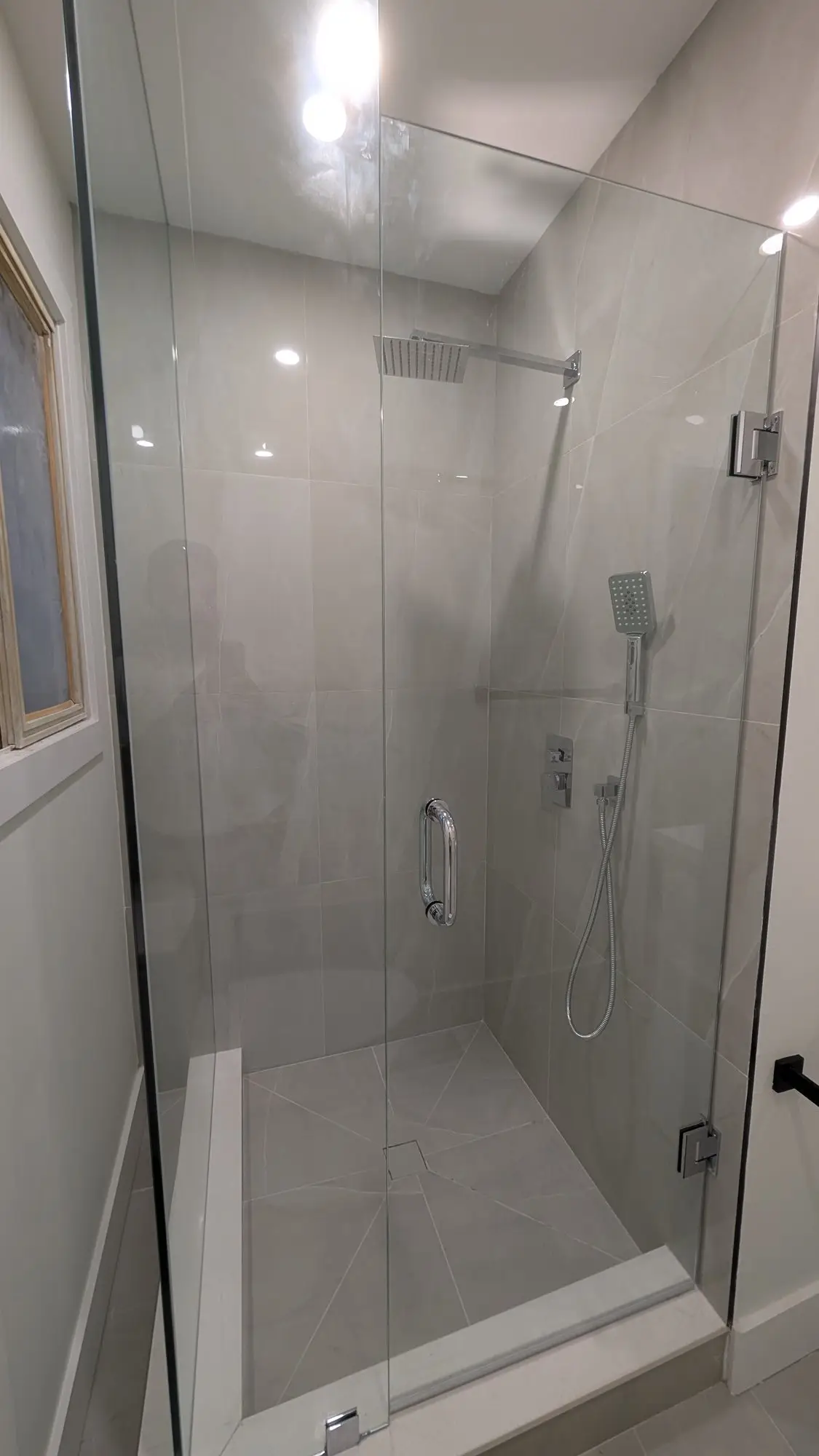 Second finished shower with glass door and tiled surround