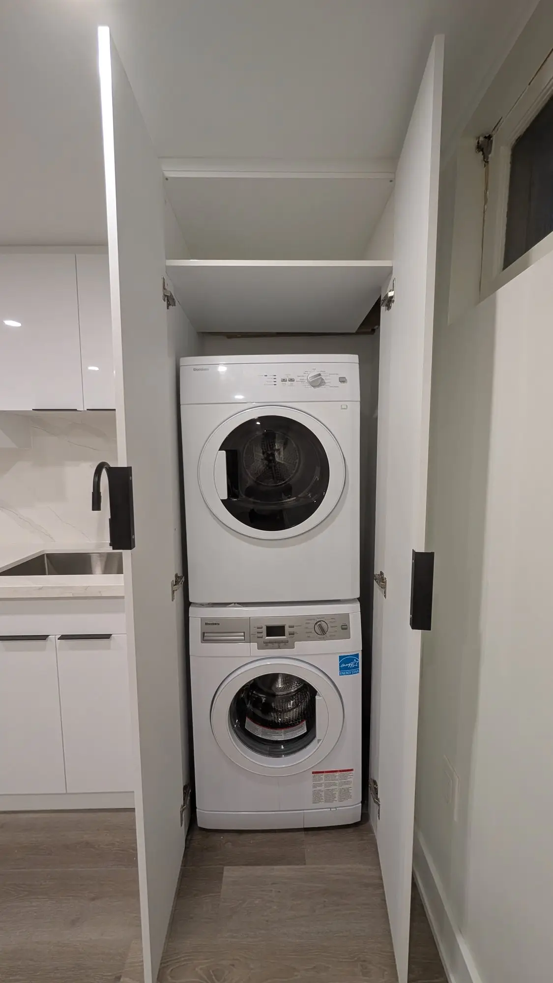 Stacked laundry in its own closet within the unit