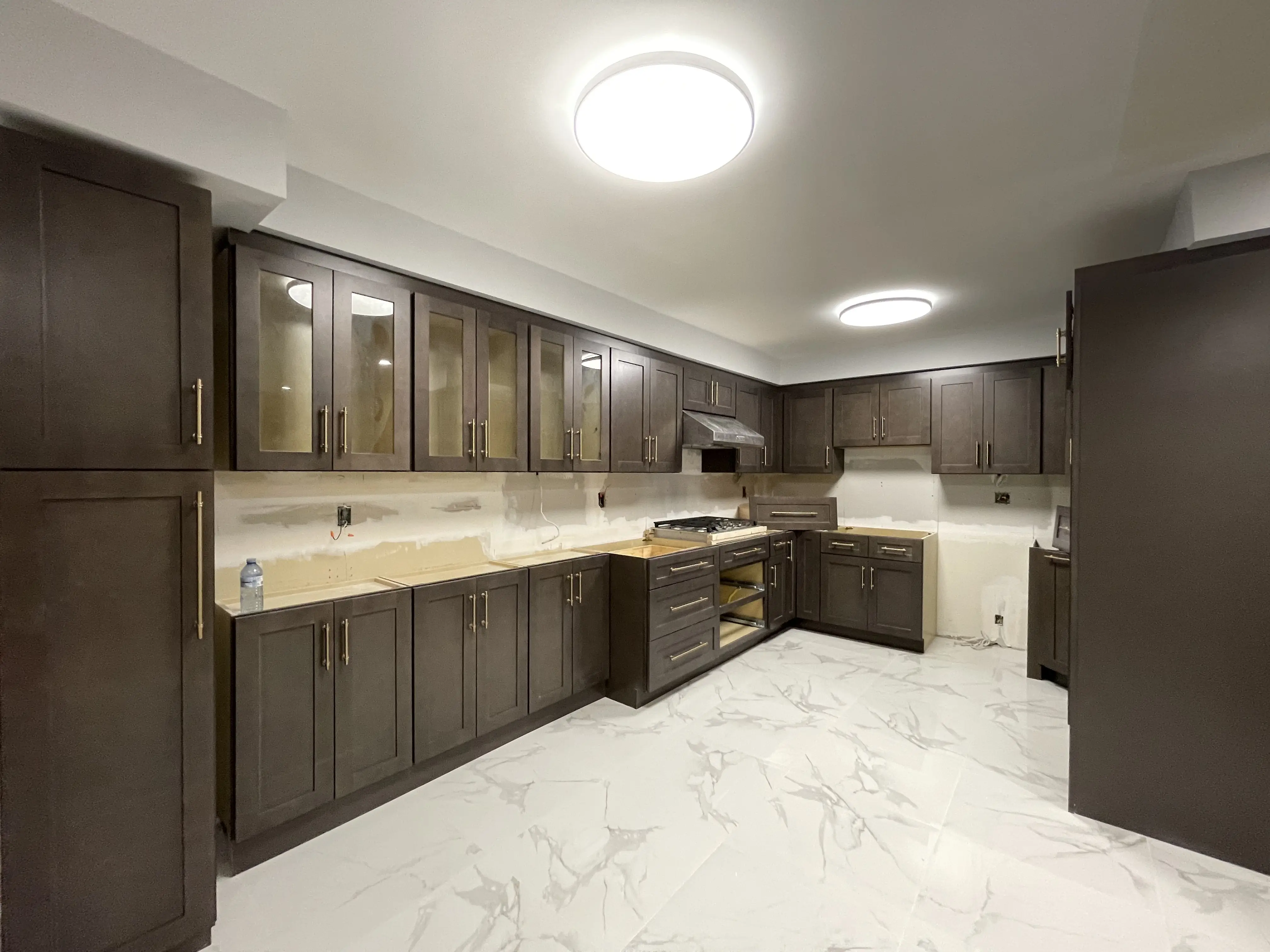 Quartz counters and full-height backsplash in a finished kitchen