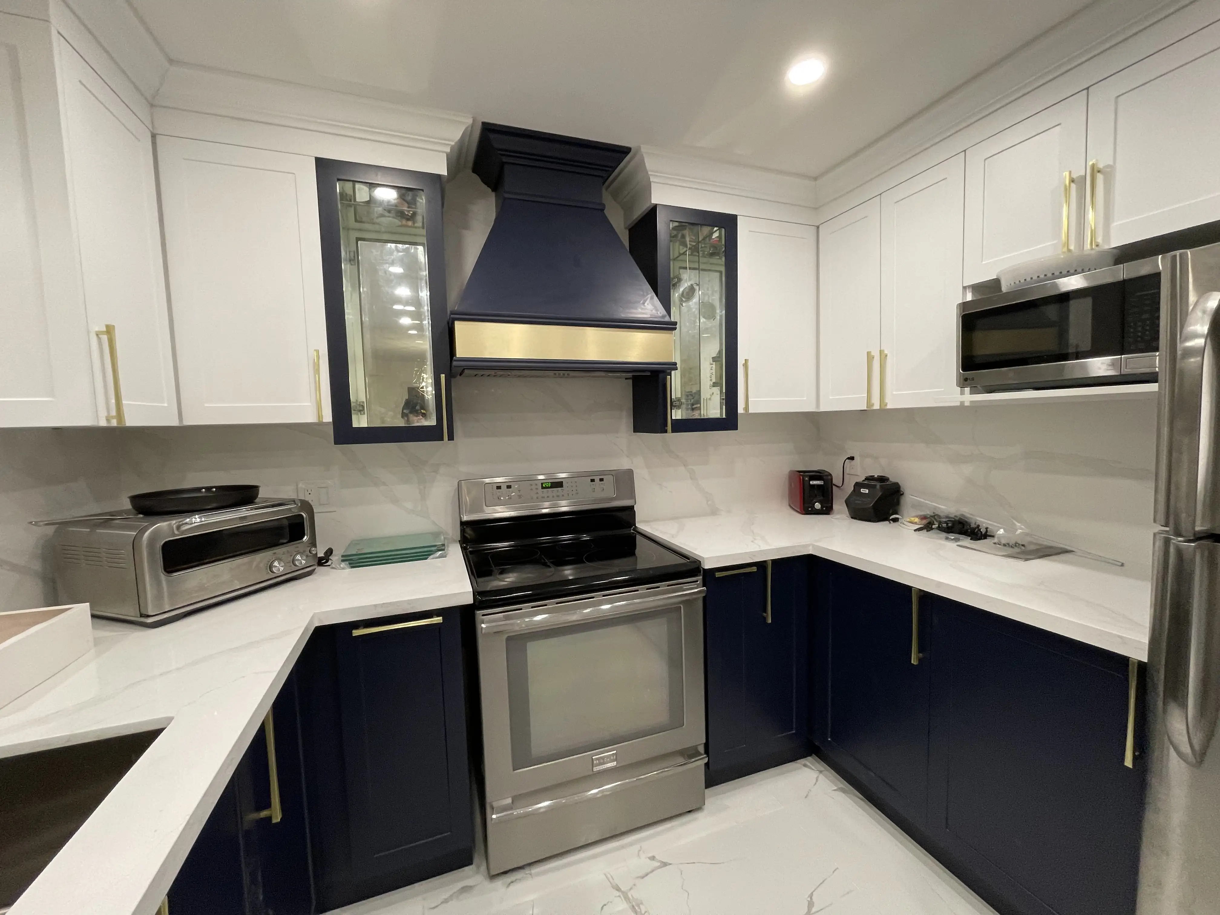 Custom kitchen renovation by HMH Construction with navy cabinets and quartz counters