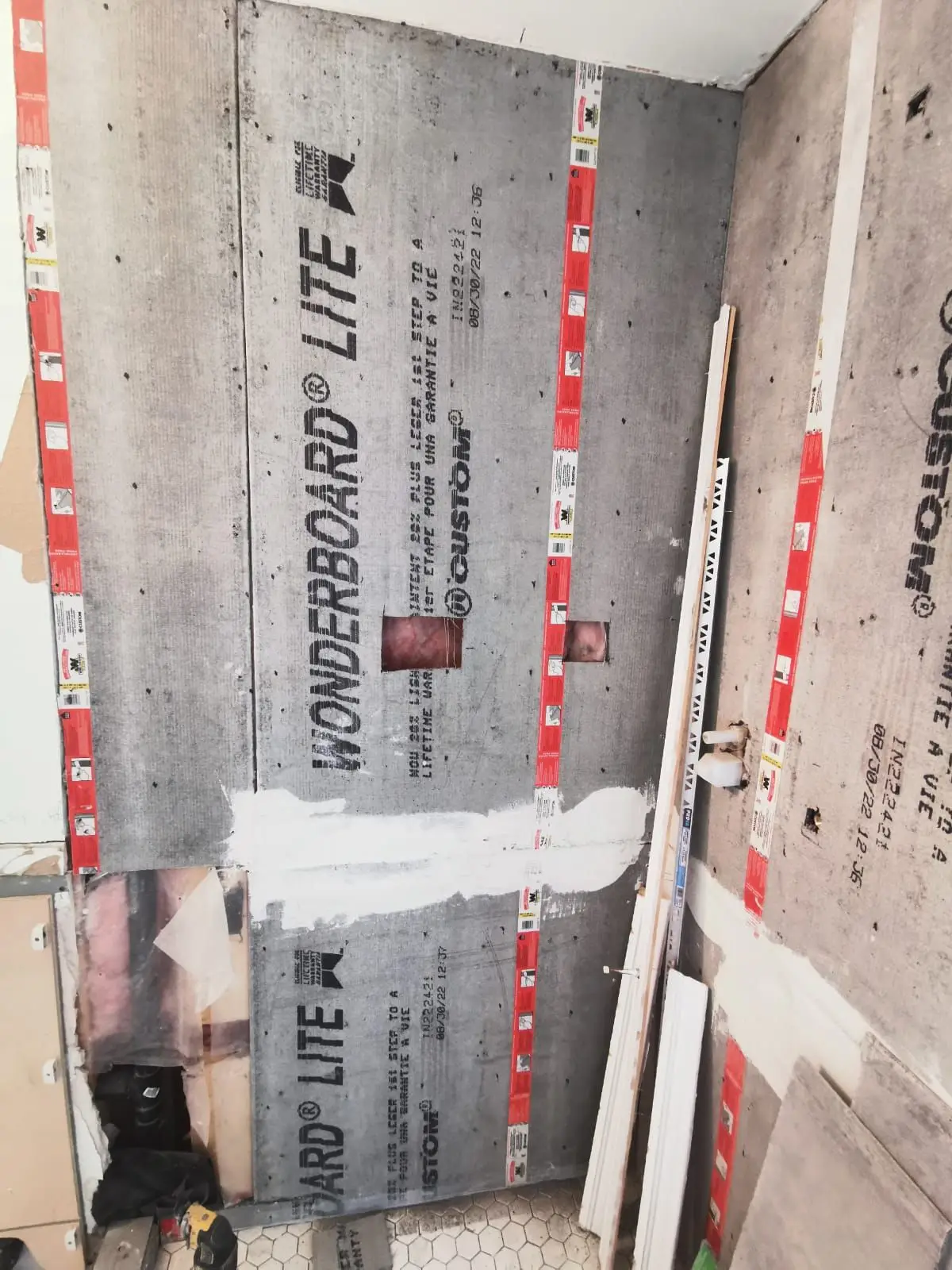 Rough-in — Bathroom wall partially installed with WonderBoard Lite cement backer board and taped seams.