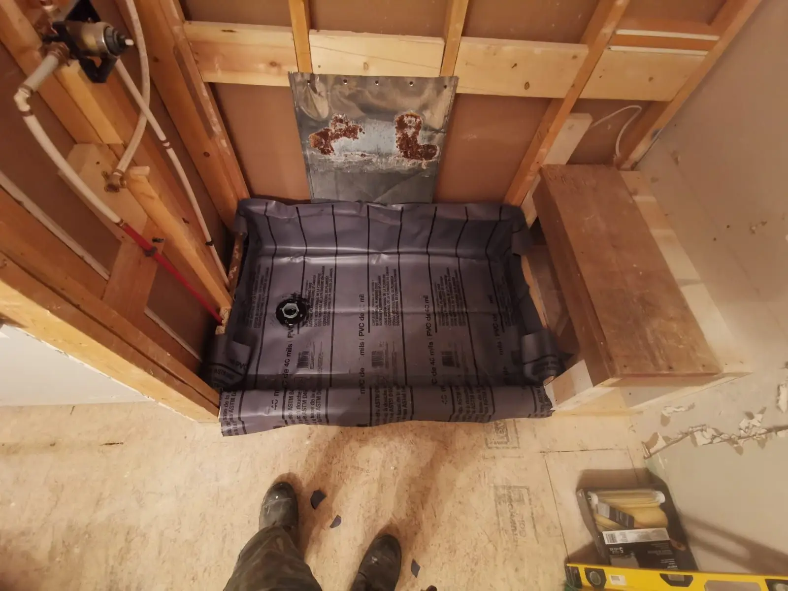 Rough-in — Shower stall framing with waterproof membrane, bench, and plumbing rough-in installed.