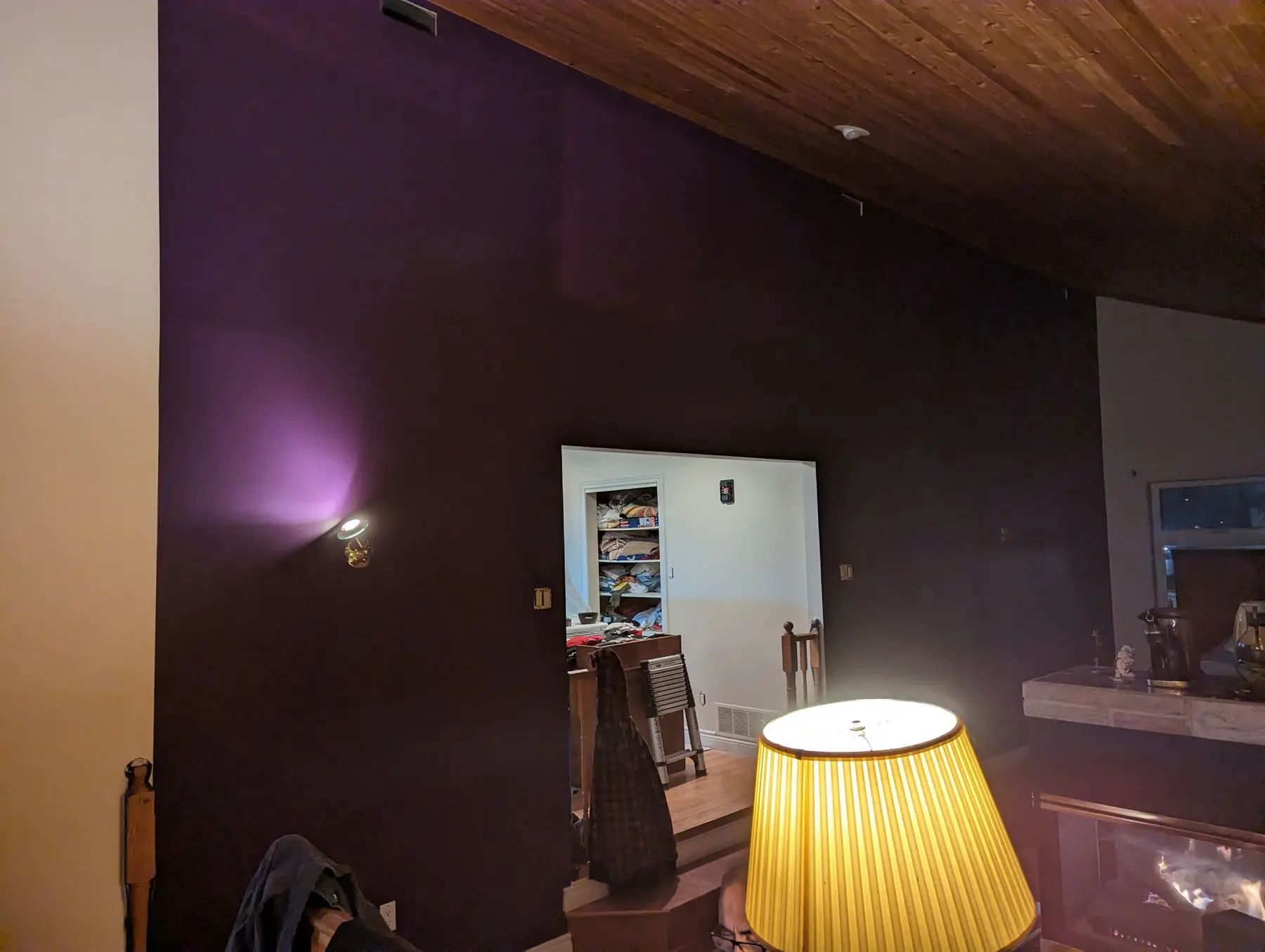 Before — Interior view showing a vaulted wood ceiling and a dark purple accent wall with a doorway.