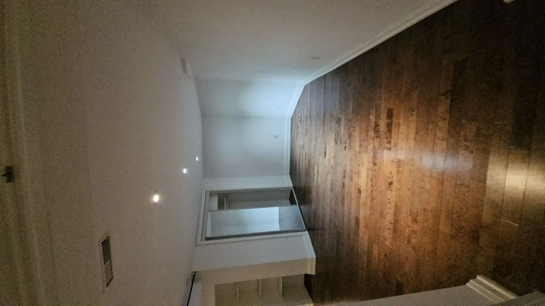 Finished — Finished bedroom with dark hardwood floors, white walls, pot lights, and a mirrored closet.