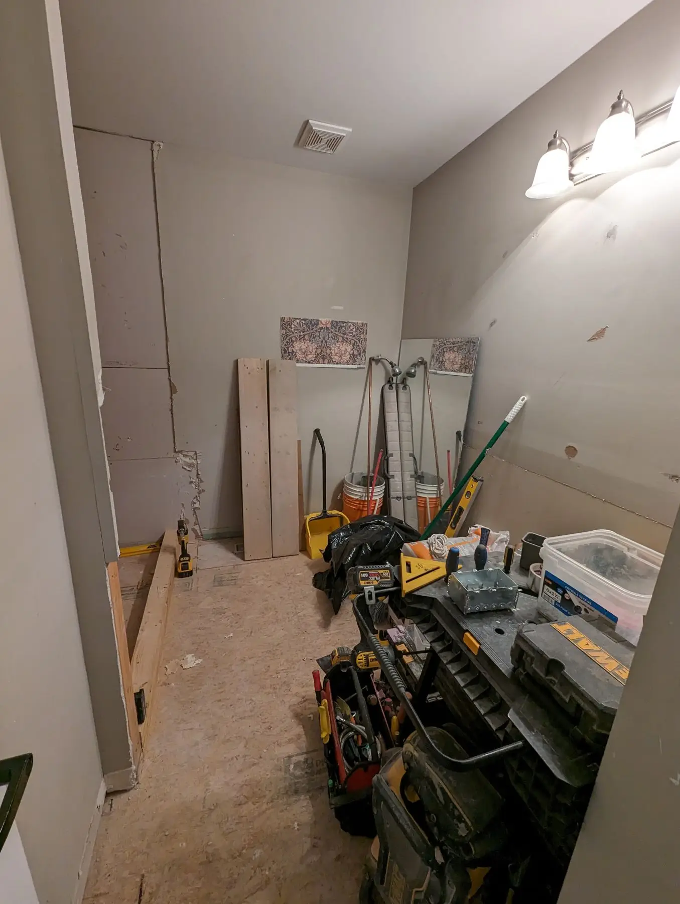 Insulation & drywall — Bathroom under renovation with tools, workbench, and unfinished drywall.