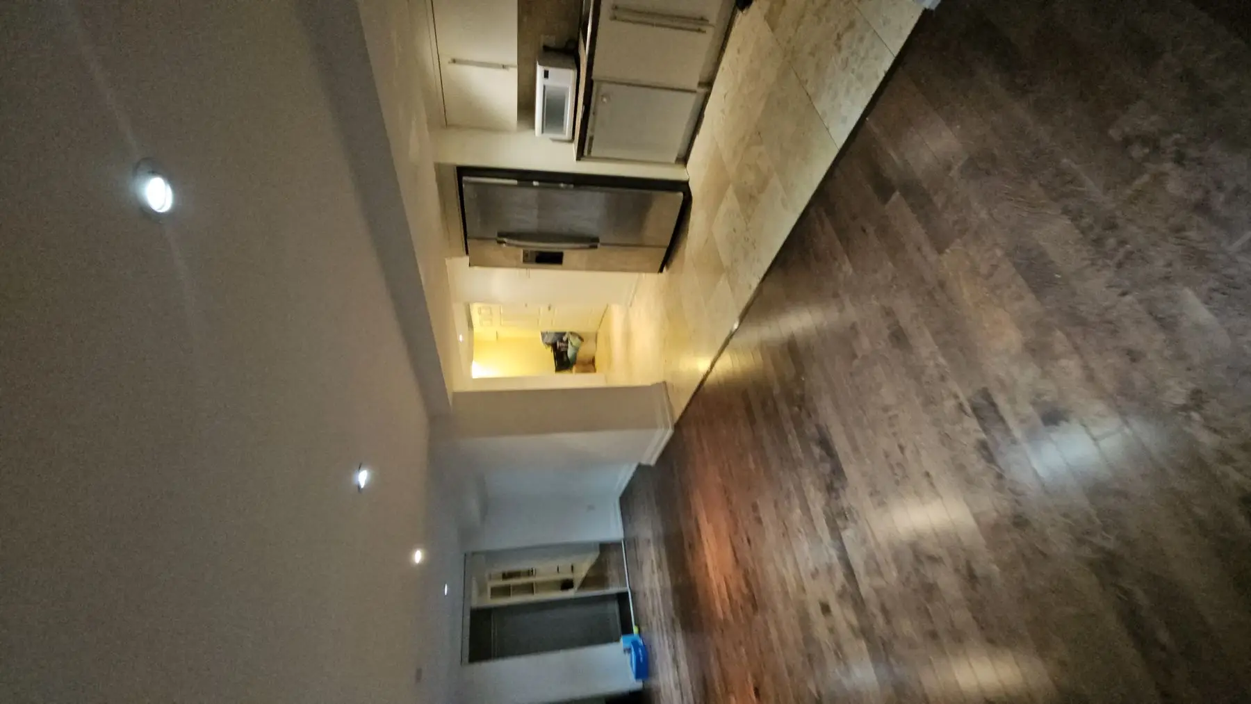 Finished — High angle shot of a finished kitchen with hardwood flooring and stainless steel appliances.
