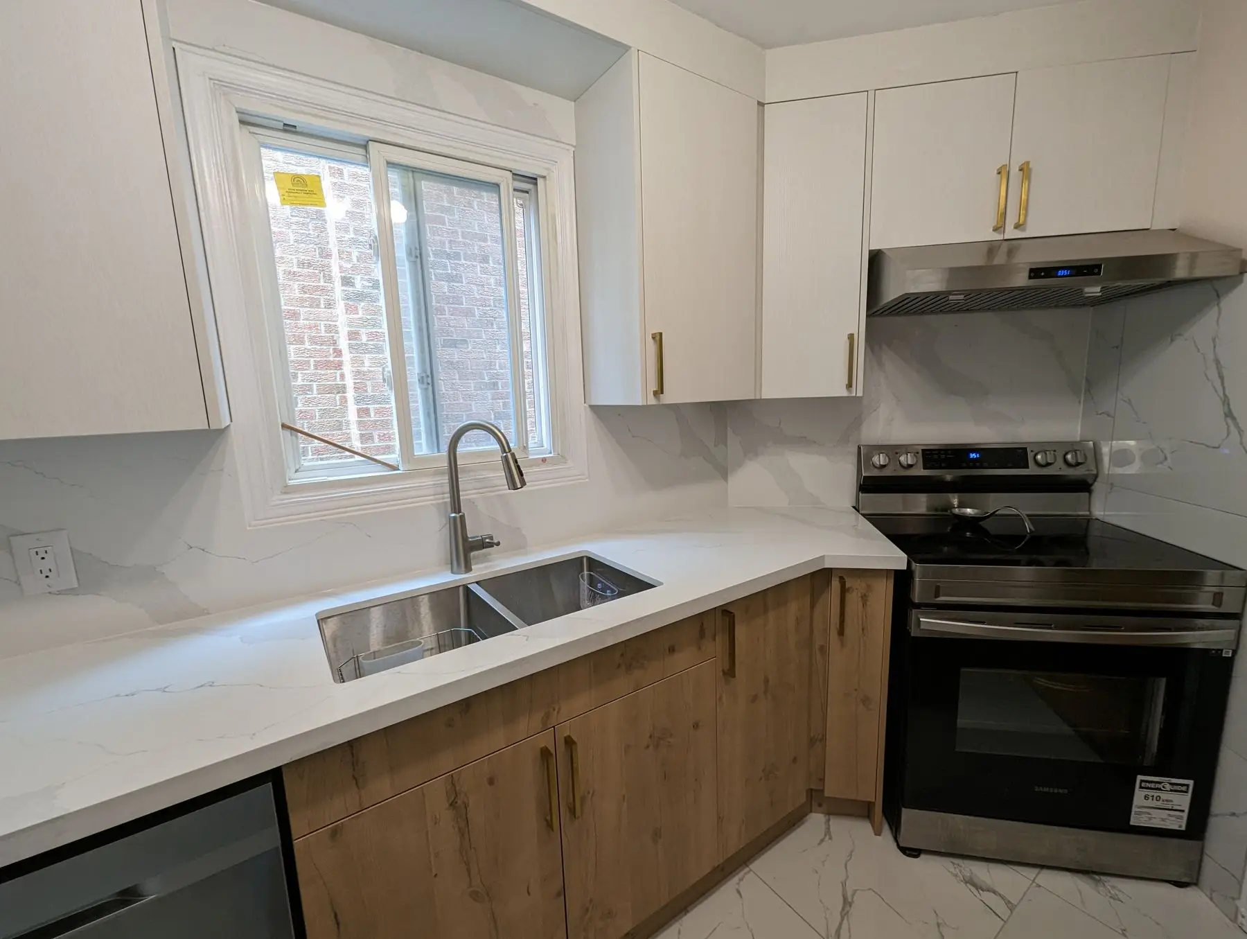 Finished — Finished kitchen featuring white quartz countertops, wood lower cabinets, white upper cabinets, and stainless steel range.
