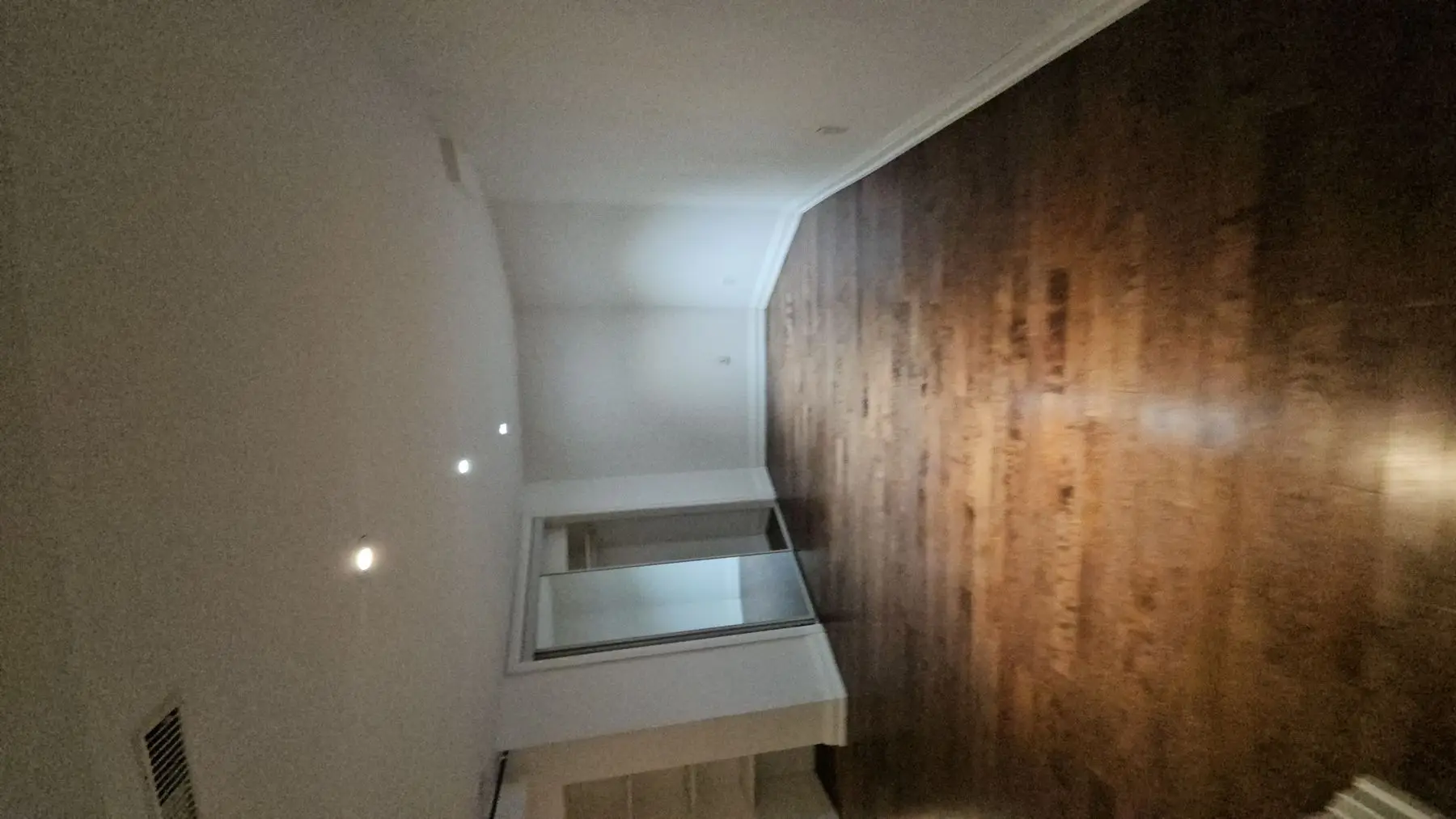 Finished — Finished bedroom with dark hardwood flooring, white walls, mirrored closet doors, and recessed lighting.